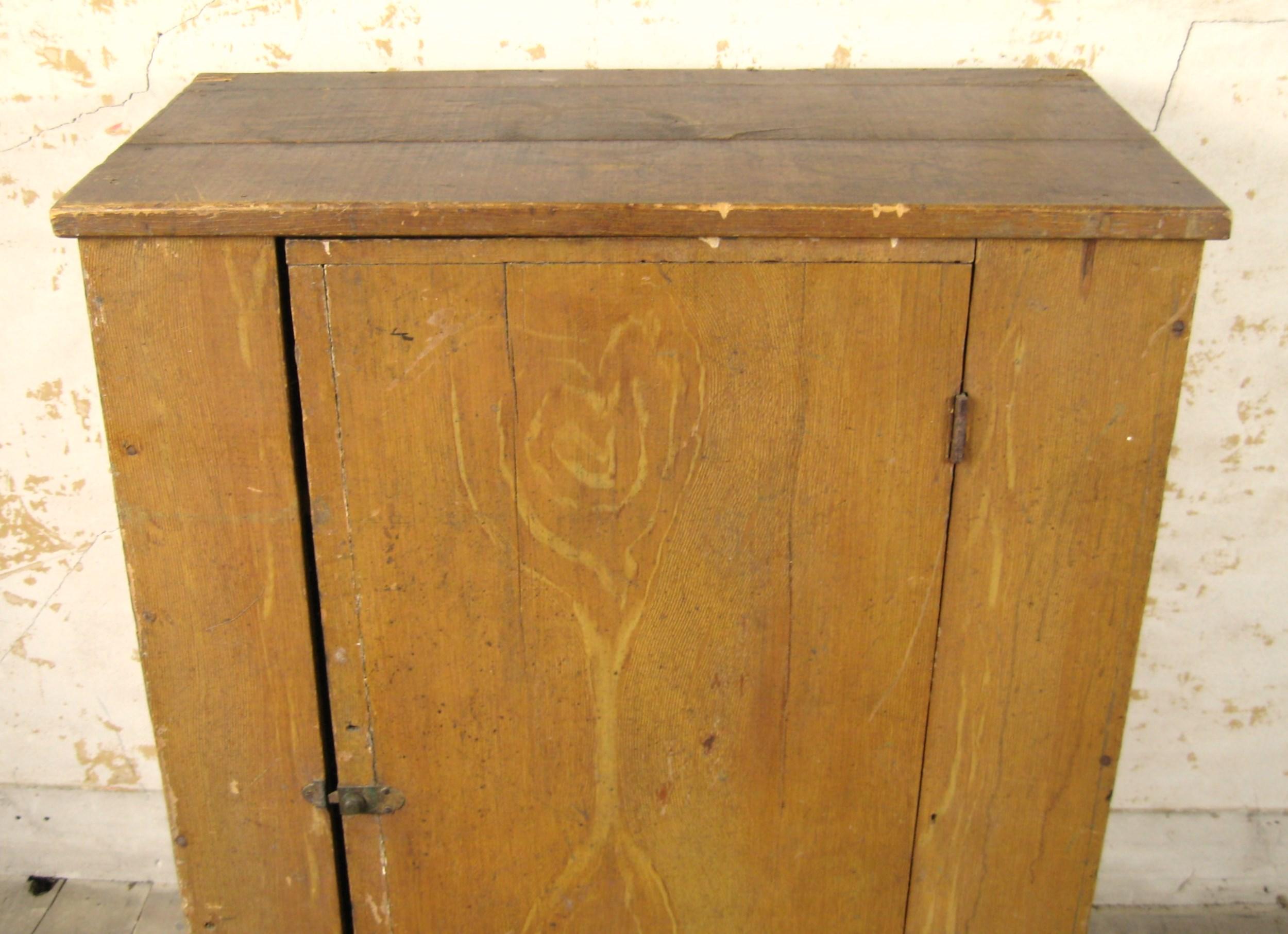This Antique Primitive Farm 1 Door blind Cupboard from the 1850's is a rare find for collectors and enthusiasts of historical furniture. Its great Grain Painted Pennsylvania cupboard, Great Painting and wood material make it a unique addition to any