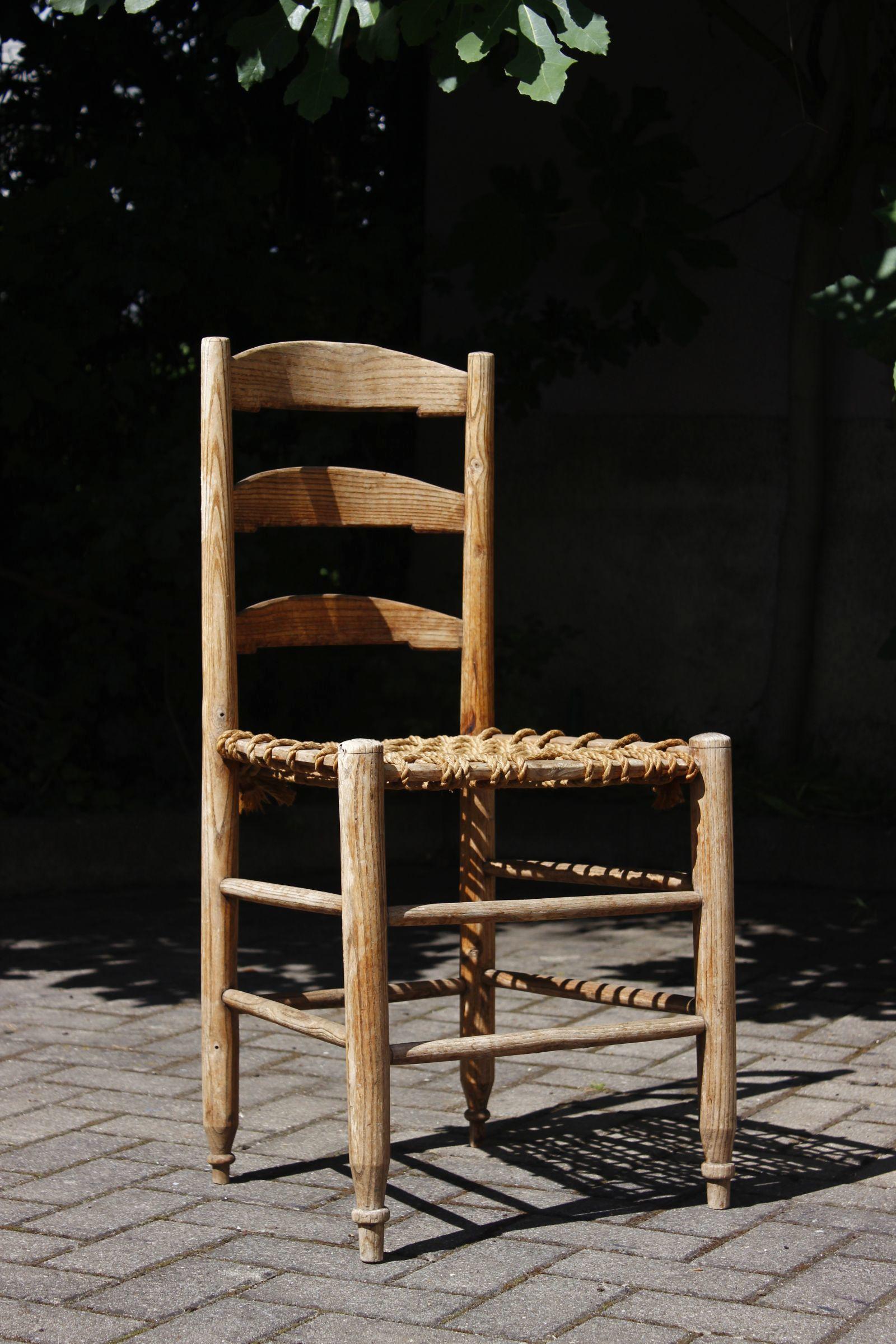 Silla de labranza casera francesa con respaldo de escalera y asiento toscamente encordado, diseño primitivo de finales del siglo XIX. En buen estado para su edad, tiene una bonita pátina envejecida y sigue siendo muy estable. El respaldo tiene unas