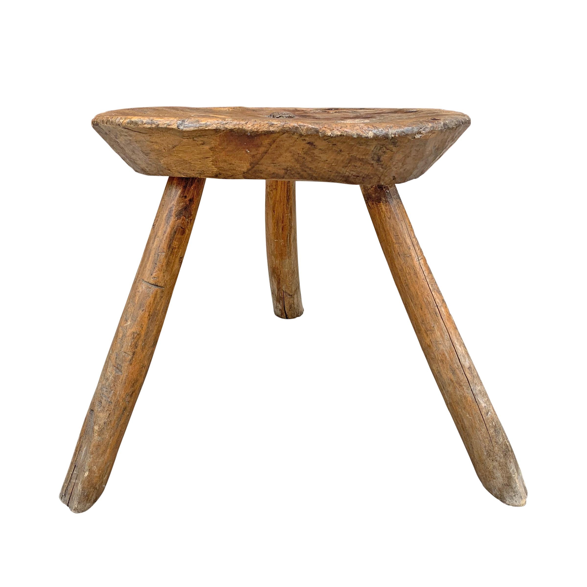 A fantastic sculptural 19th century primitive European milking stool with three splayed legs with through tenons, and a beautiful patina.