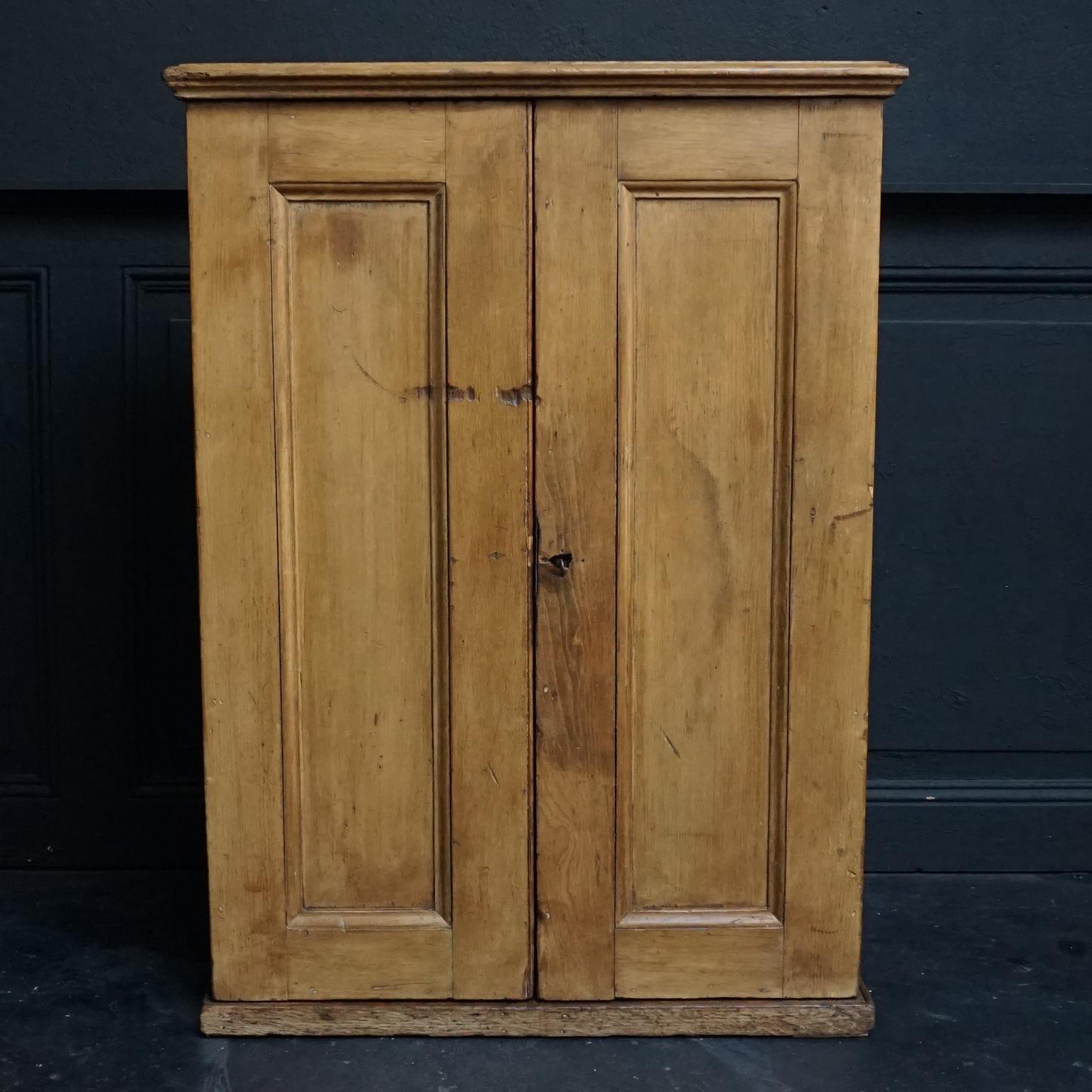 Unusual antique pretty little antique pinewood cupboard for on top of a counter or table, with two double deep smoothly swinging opening doors and double lock mechanism.

Shelves both in the interior of the cabinet and in the door, which is pretty