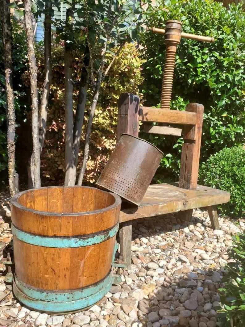 A charming wood and iron wine press from the 19th century. Handcrafted in France, freestanding, with warm, rich, wonderfully aged and weathered antique wood color, soft rustic wood tones, accented by patinated cast iron, with the original, naturally