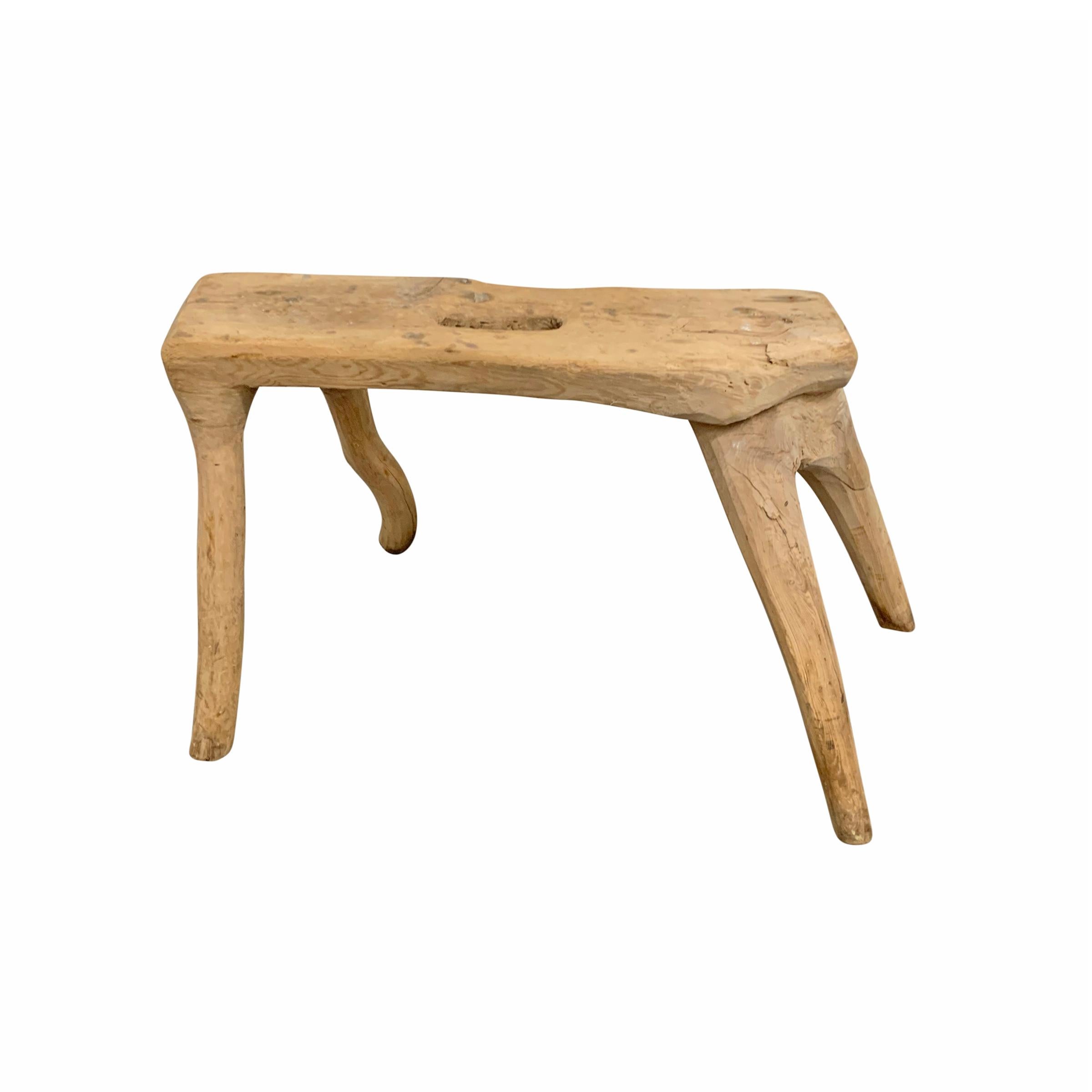 A fanciful and sculptural 19th century Swedish Primitive pine root-wood stool with four splayed legs and a hole cut into the seat used for carrying.