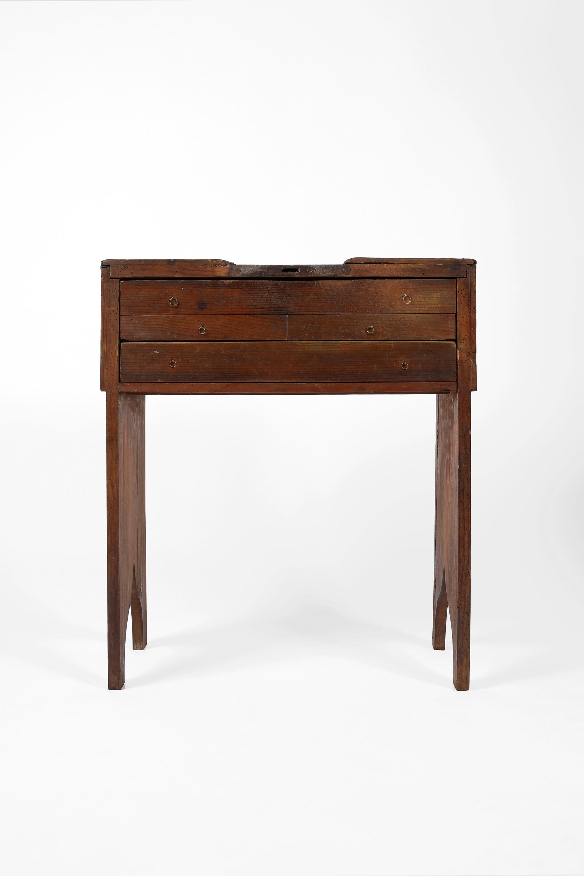 A late 19th century goldsmiths workbench, solidly constructed in heavily patinated pitch pine timber. Featuring an inset ironwork hammering plate and gallery top with multiple drawers beneath. Portuguese, c. 1880. 