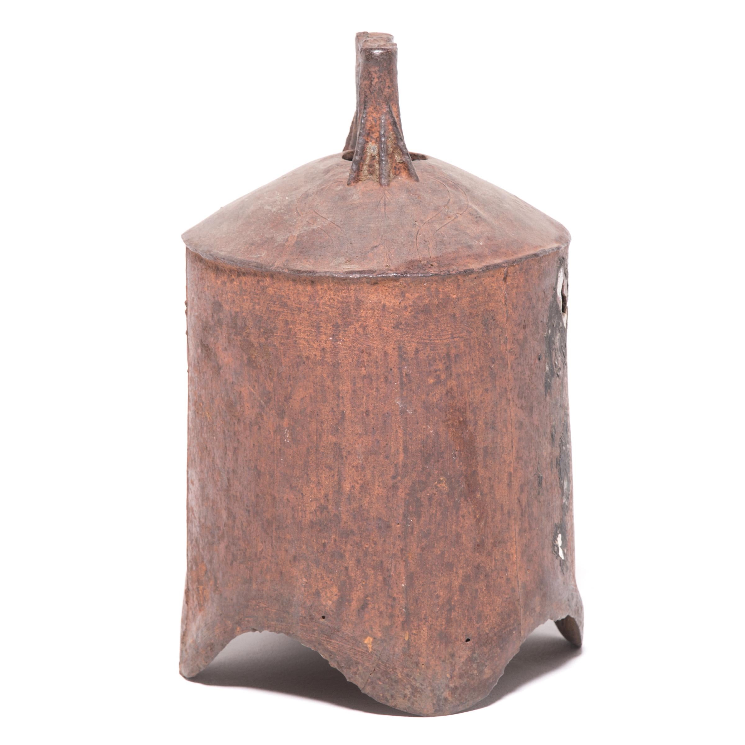 This rustic, 19th century iron bell once pealed in celebration or gave notice of important events in a town in northern China. The shoulder of the bell is adorned with subtle decorations, including a fish in low relief, a symbol of wealth and
