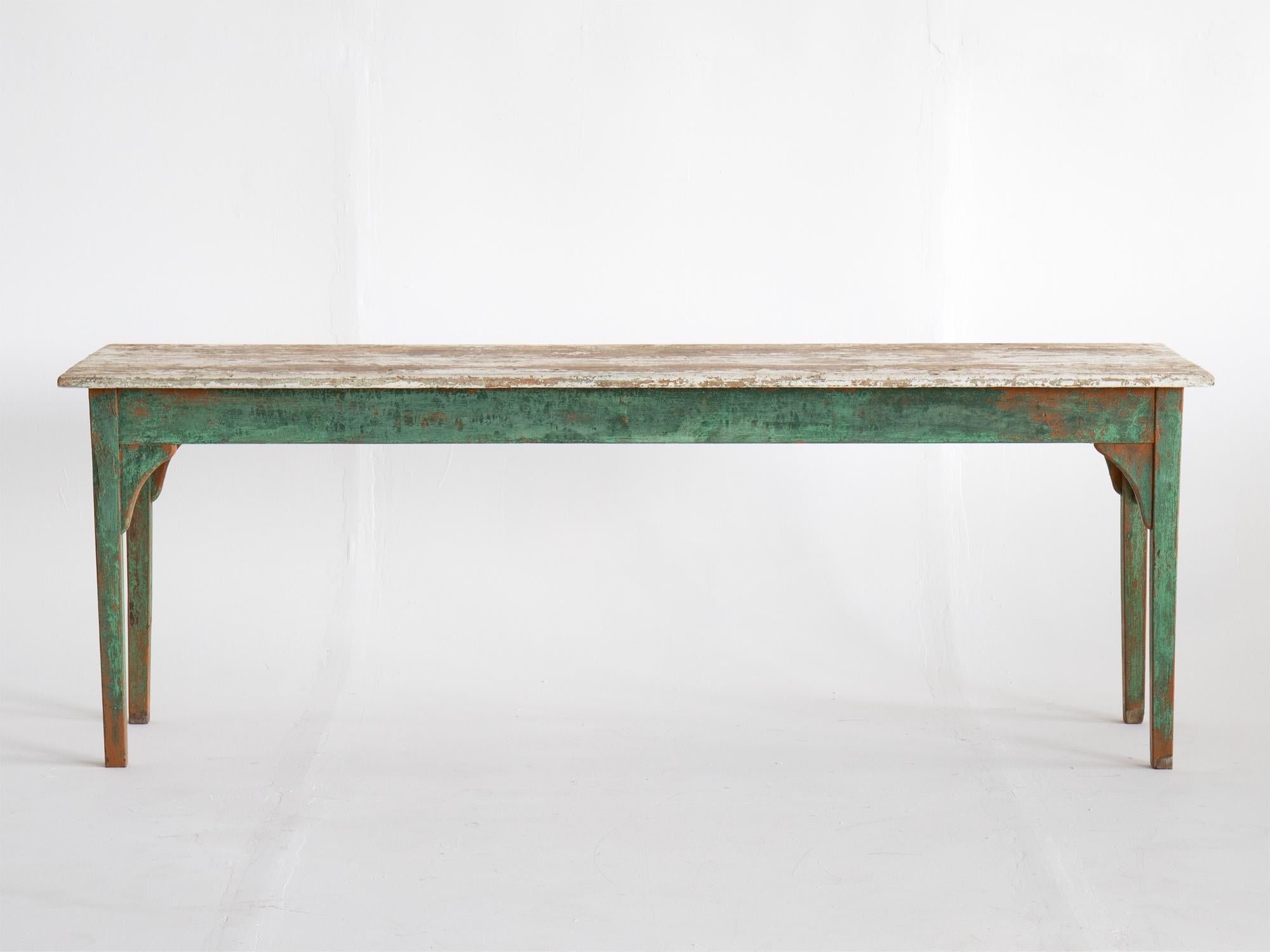 A provincial painted pine table. Swedish, 19th century. The plank-formation top raised on tapered legs. A versatile piece - narrow enough to use up against a wall as a hall/console table or may also be used in the centre of a room.