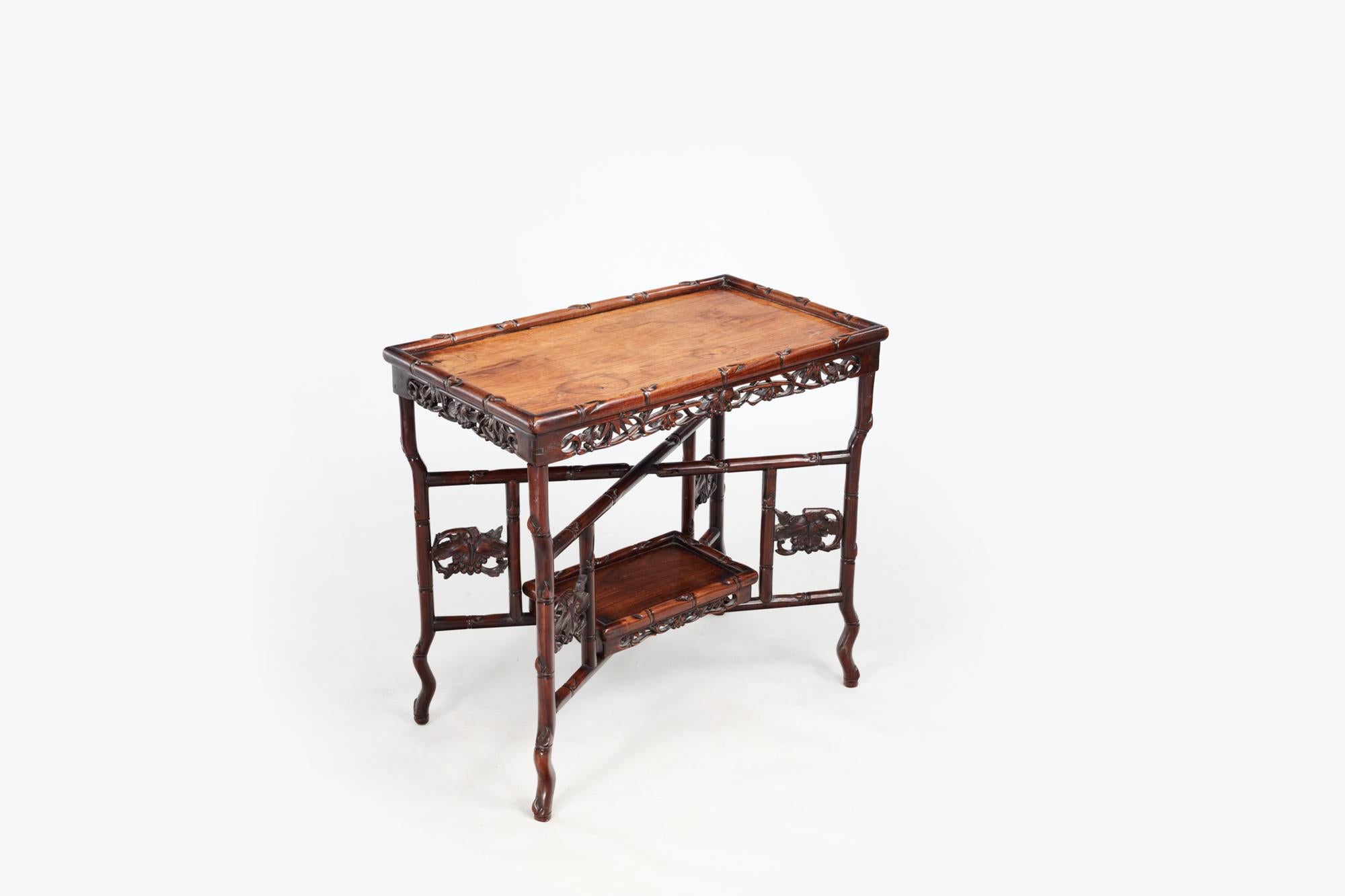 19th Century Qing Chinese export hardwood tray top table with folding frame and removable undertier. The heavy rectangular tray top with a decorative carved apron above a folding hinged 'x' shaped stretcher base with carved legs and stylised bamboo