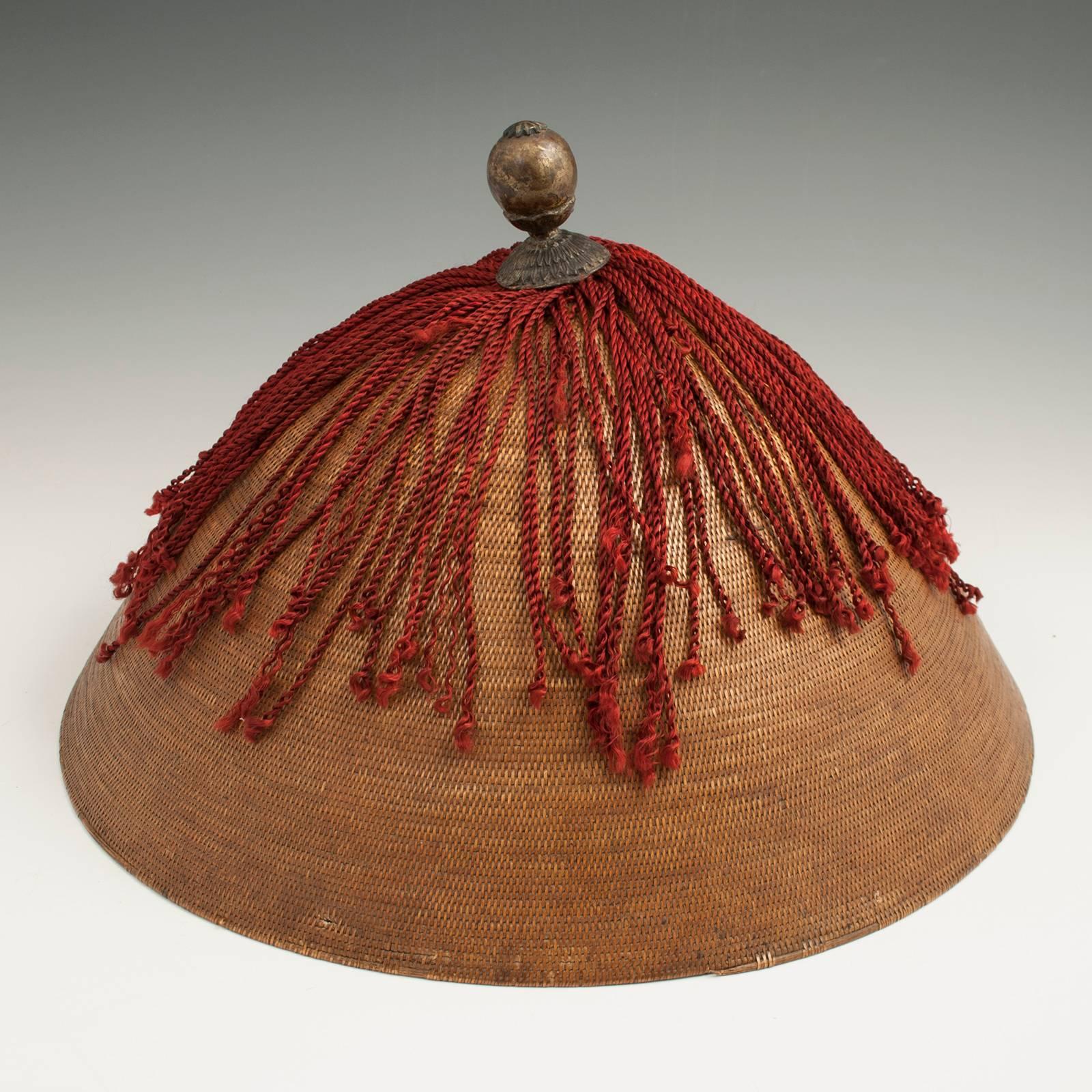 Offered by Zena Kruzick
19th century Qing dynasty man's wicker summer hat and leather hat box, China

A man's summer hat made of woven wicker with the original silk fringe and metal finial. It fits neatly in the accompanying red lacquered leather