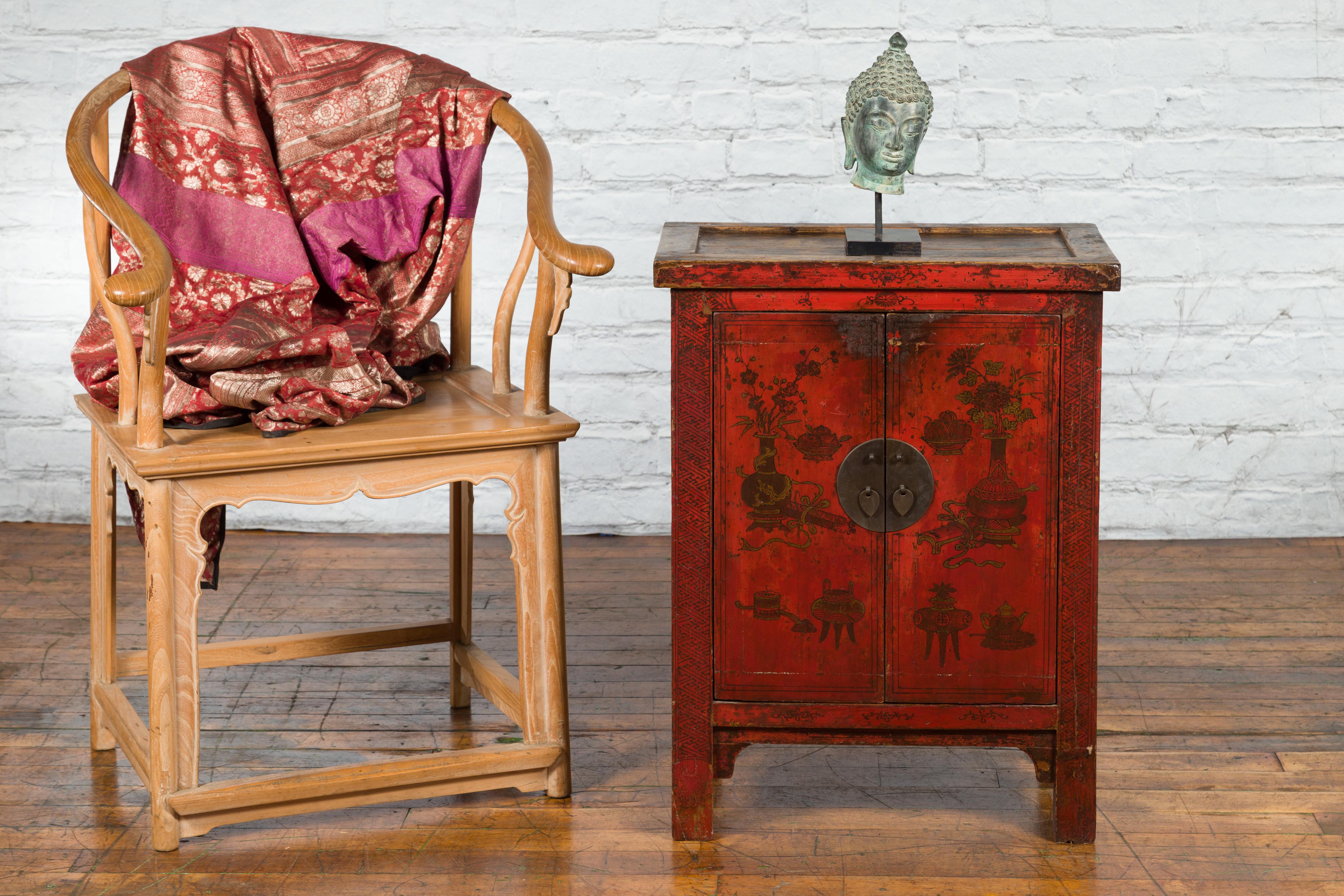 A Chinese Qing Dynasty period red lacquered small cabinet from the 19th century, with painted flowers and vase scene. Created in China during the Qing Dynasty, this small cabinet features a linear silhouette perfectly complimented by a red lacquer.