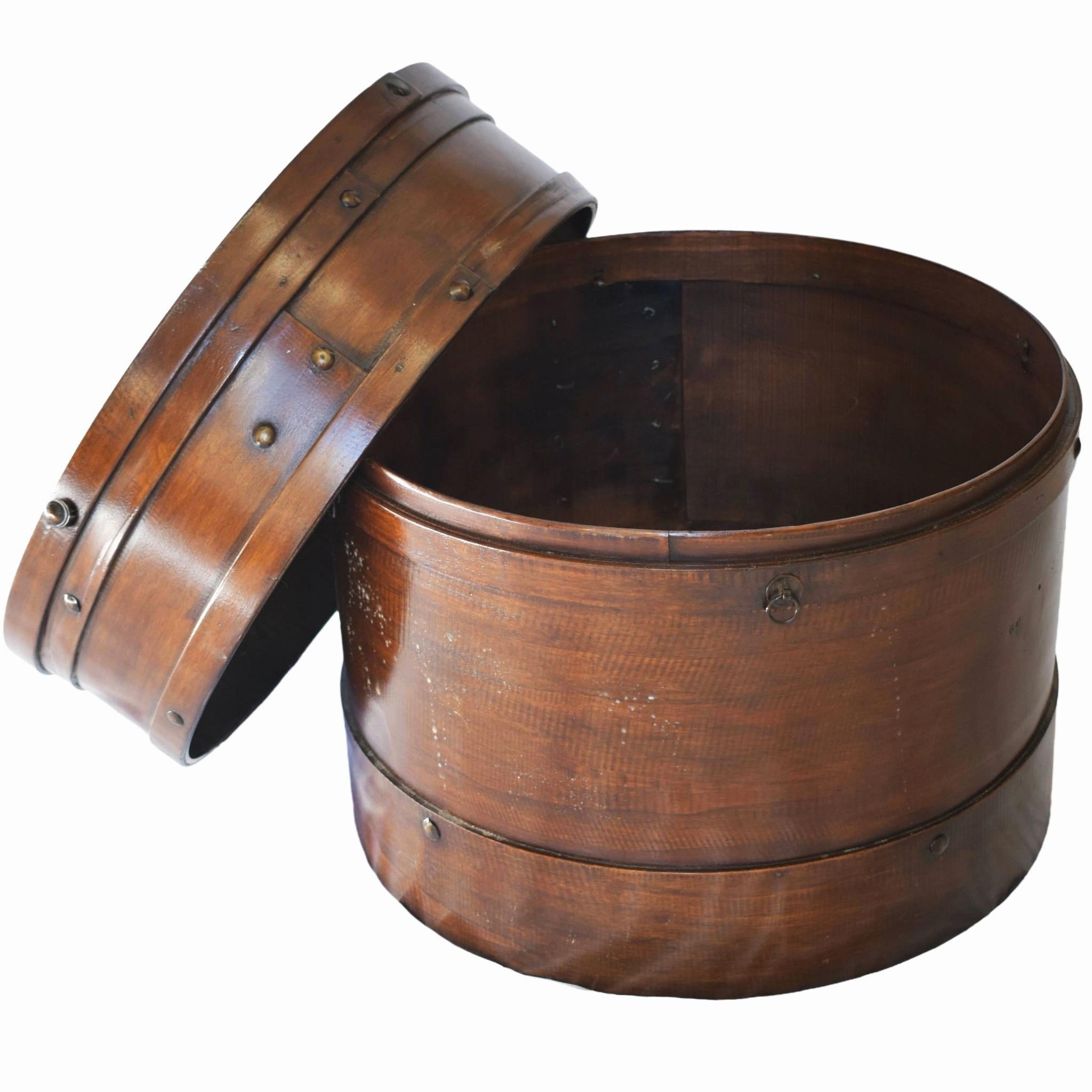 These boxes were initially used for food storage or refrigeration in ancient China. A circular shape made of elmwood bentwood with wrought-iron rivets, brass ring handles, and a lift-off cover, this also doubles as a side table or decorative