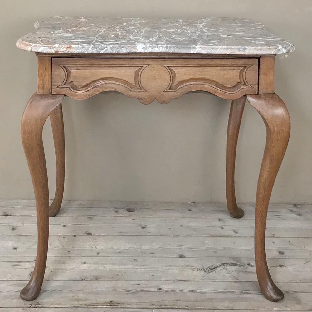19th century French Louis Philippe walnut marble top writing table represents the epitome of the style, with boldly scrolled, broad shouldered cabriole legs with club feet supporting a subtly scrolled and paneled apron, all underneath the