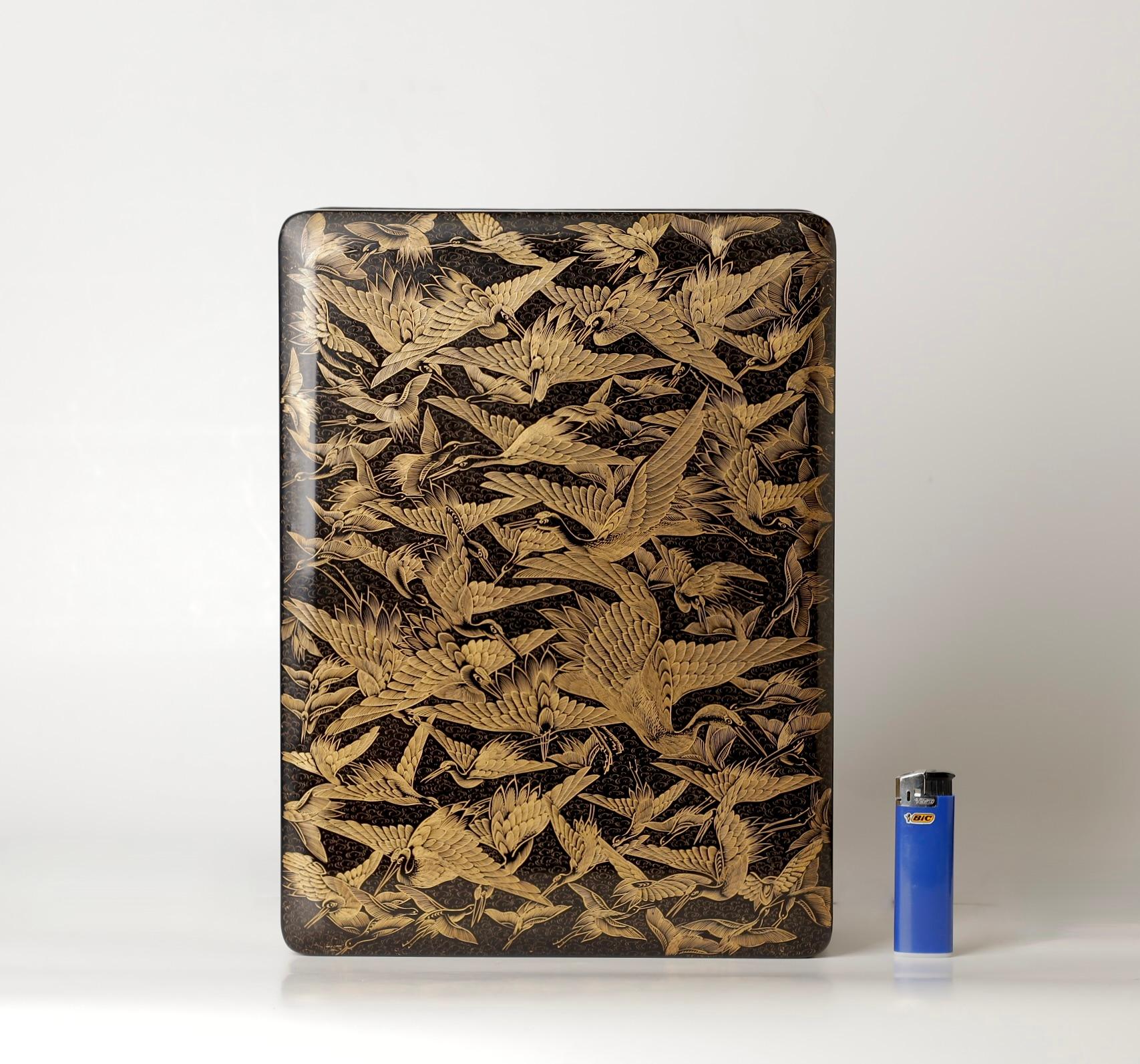 Boîte finement laquée avec un motif incisé, rempli d'or. 
Remarquable boîte laquée du 19e-20e siècle, décorée de grues volantes.  

Sa forme unique allie l'artisanat traditionnel à de subtiles influences Art déco. La surface laquée noire lustrée est