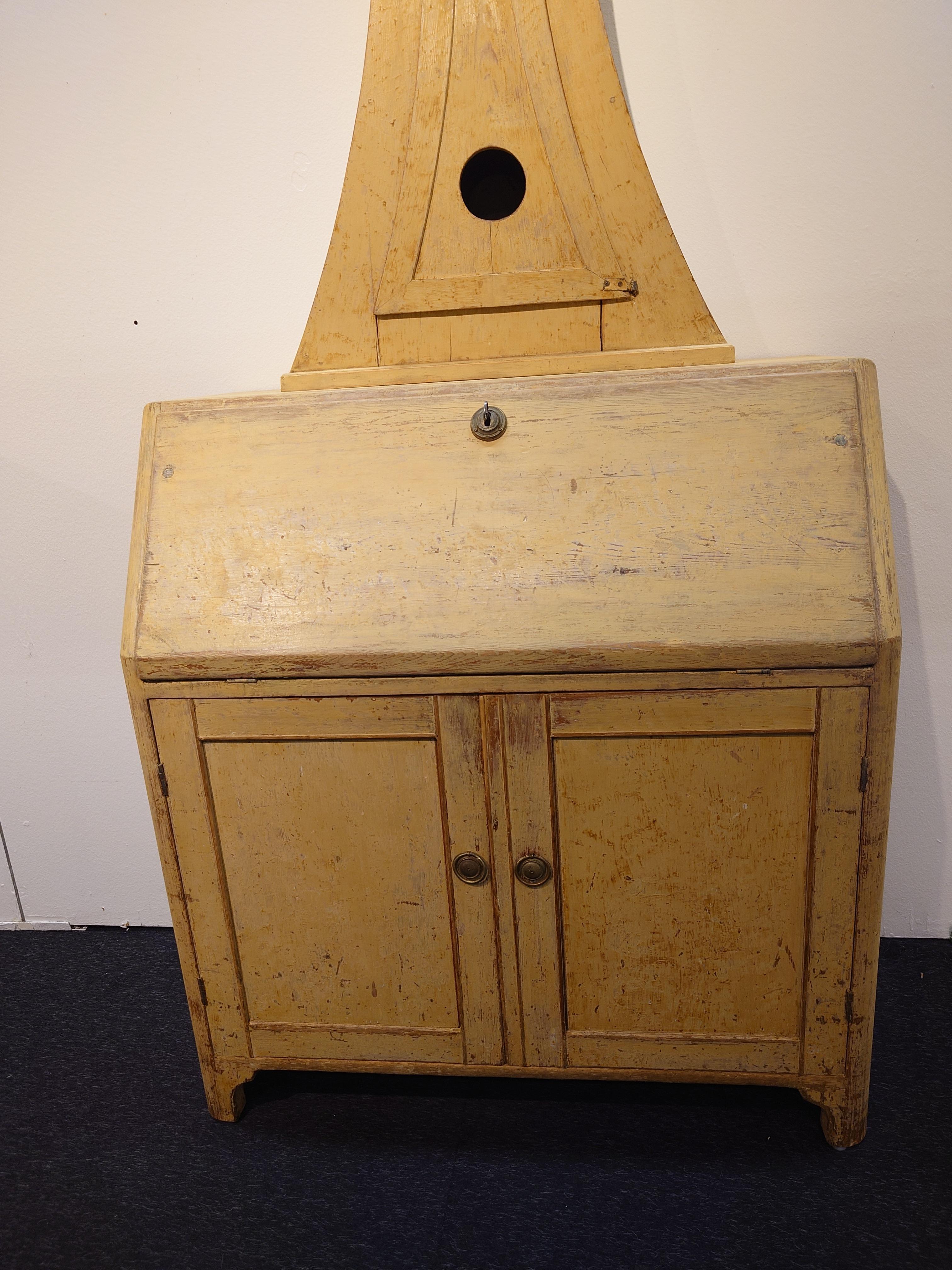Antigüedades suecas del siglo XIX  mueble reloj de Umeå Västerbotten ,norte de Suecia. . Un buen ejemplo de ingenio antiguo y vida compacta, esta pieza combina tres funciones en una: reloj, escritorio y armario. Fabricada en pino y raspada en seco a