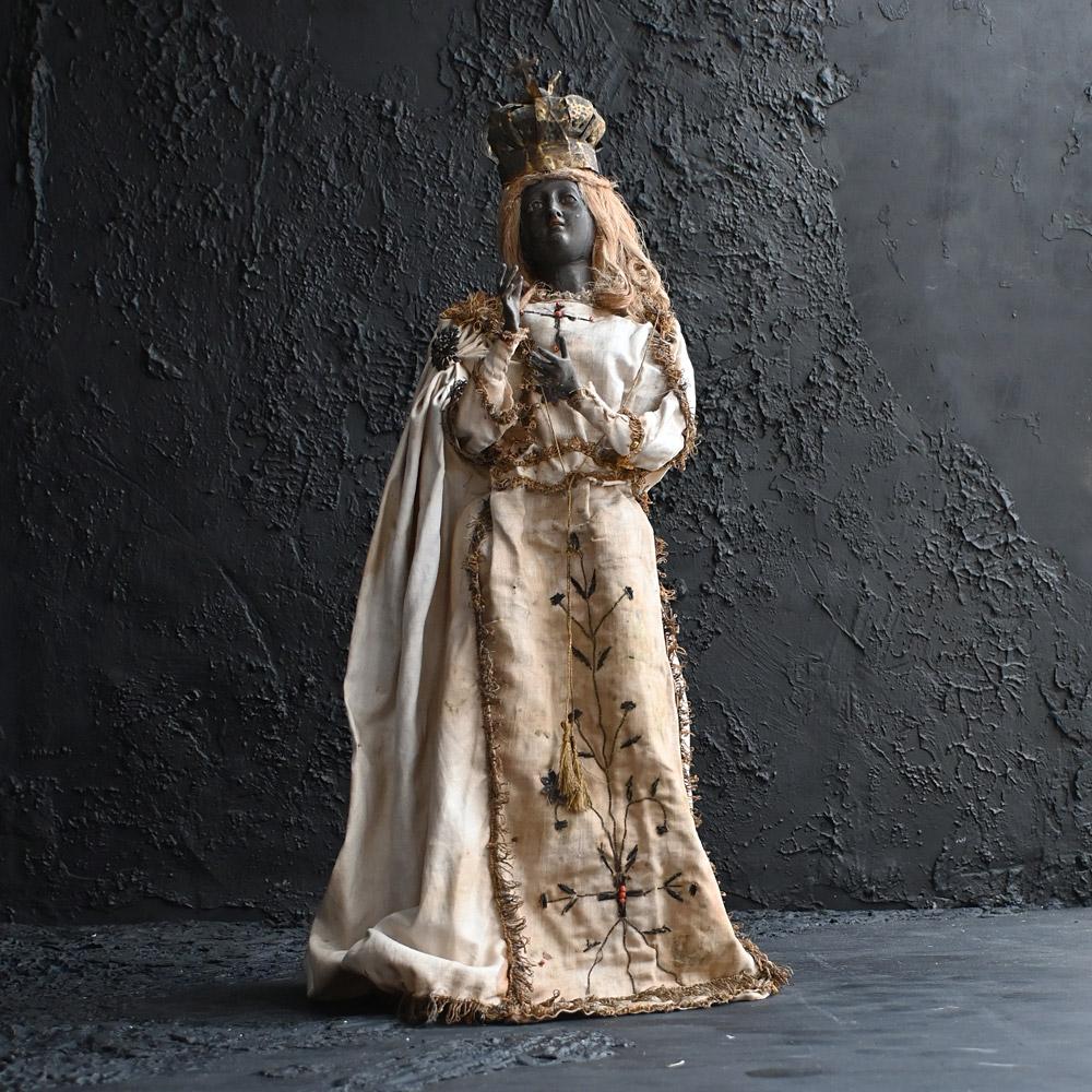 19th Century Rare Black Madonna Figure

A hand crafted and rare example of an early to mid-19th century black Madonna figure. Dressing in its original embroidered silk gown with gold threaded tassels. Real hair, glass eyes and brass fitted crown.