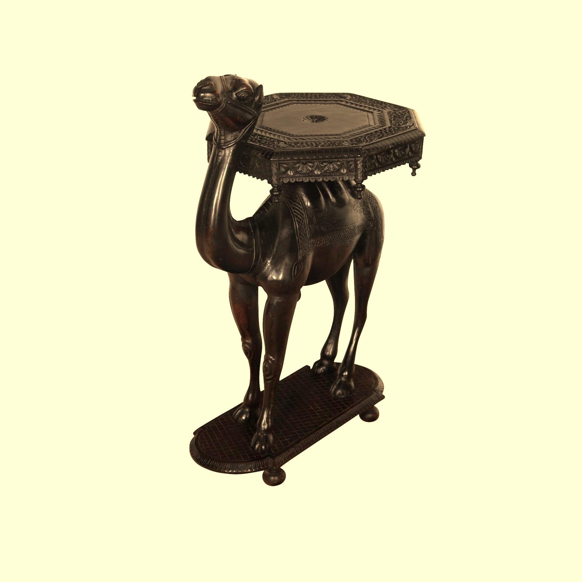 A rare large late C19th Anglo Indian Hardwood Camel Occasional/End Table of larger than normal proportions. The top consists of a carved octagonal top with foliate design and repeating frieze with finials. The top fixed to the bold body with carved