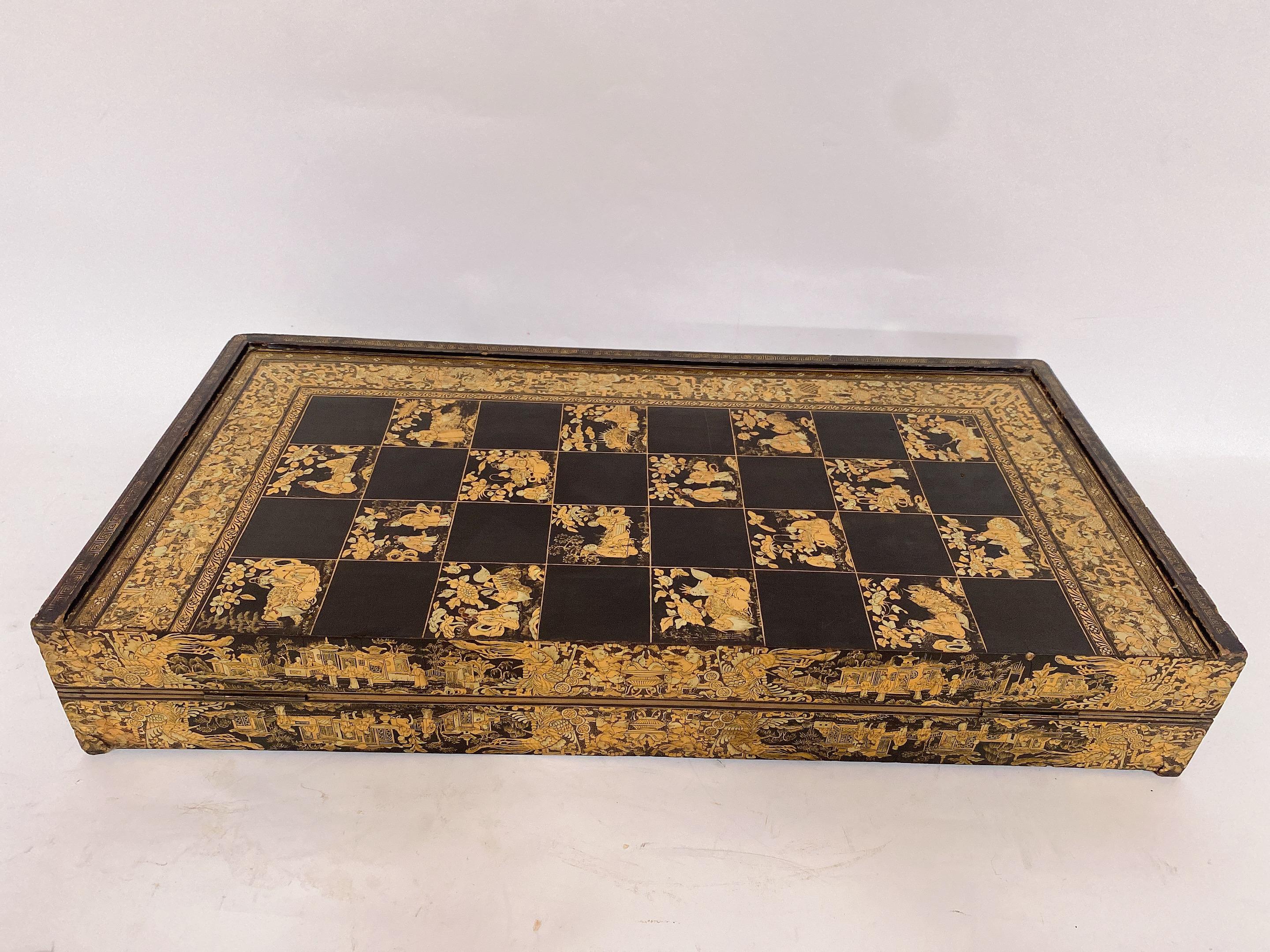 19th Century rare large 25'' Chinese export gilt decorated black lacquer gaming board box, finely decorated with gold on a black background of characters, fantastic animals, bats and floral arrangements. it is very large unique piece, The outer part