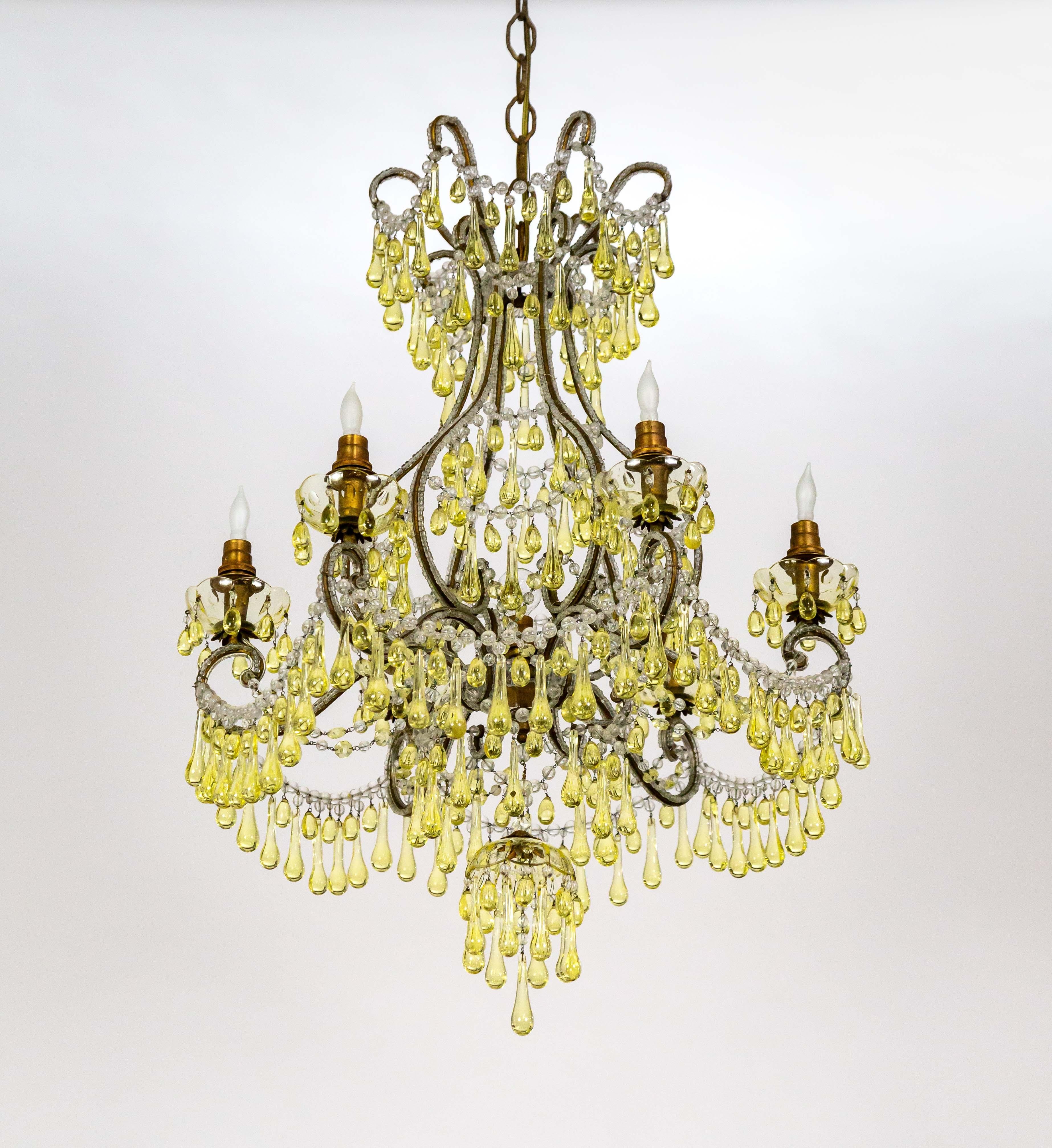 This stunning chandelier with rare pale-yellow bobeches and drop crystals was made circa the mid-1800s and was originally lit with candles. We electrified it with 6 lights on the arms and one center light. It has beaded strands along the arms,