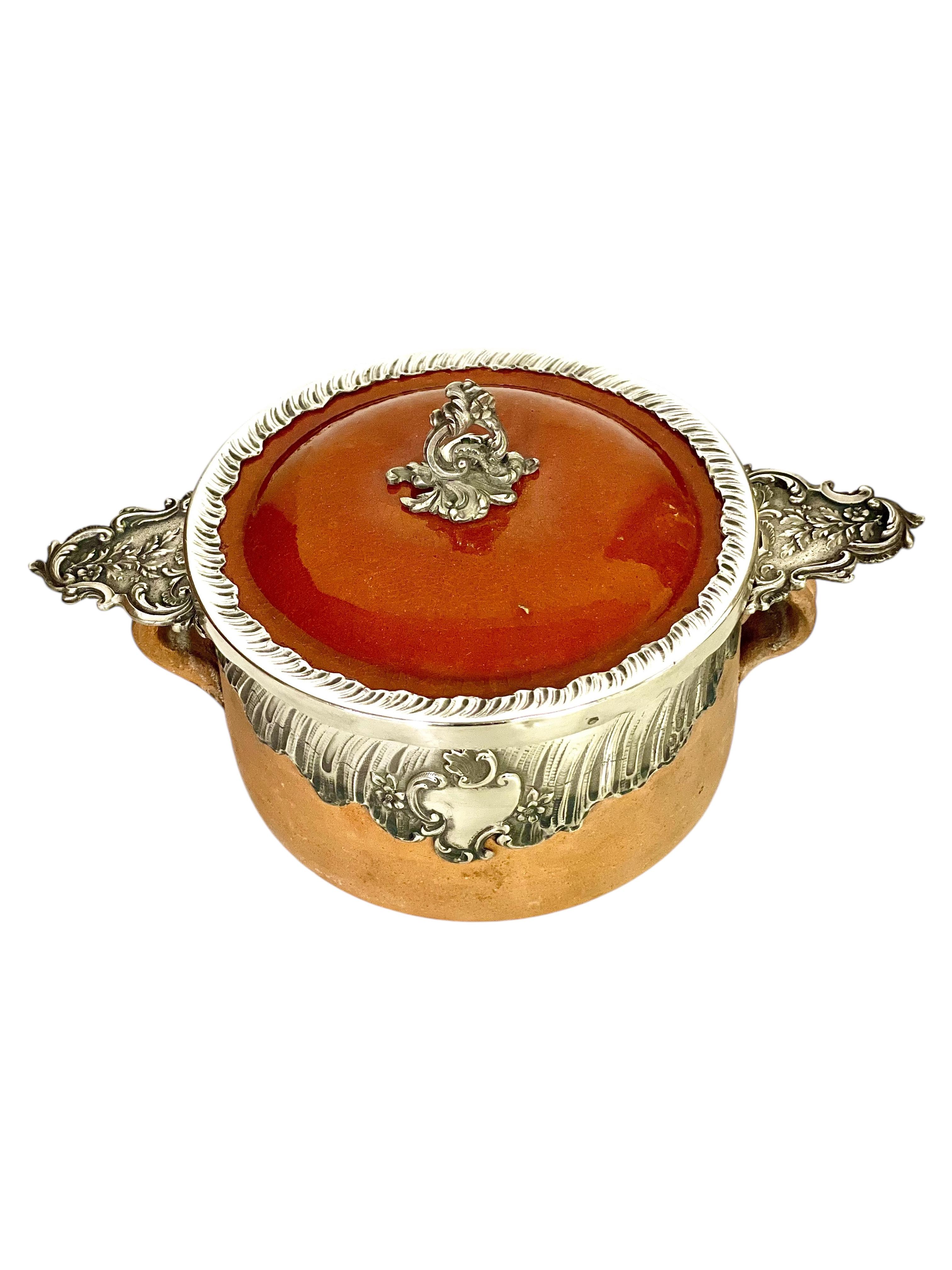 Esta exquisita fuente francesa del siglo XIX ejemplifica la refinada artesanía de la época, combinando a la perfección la loza rústica con elegantes detalles de plata. El cuenco de terracota presenta un rico interior esmaltado, que garantiza tanto