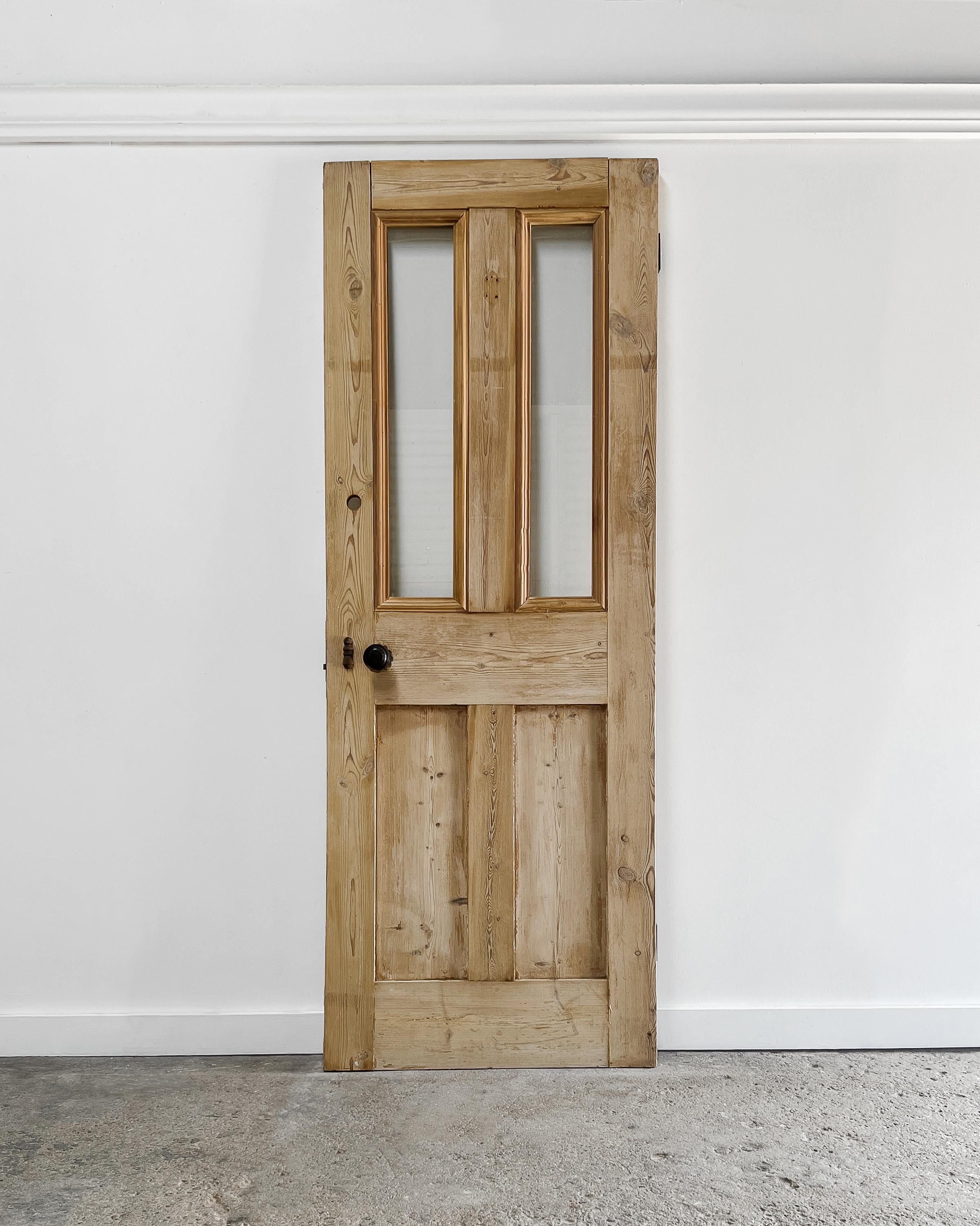 Elevate the contemporary ambiance of your home with the addition of a reclaimed English pine door, boasting a 2-lite over 2-panel design. Beveled trim accents highlight the door’s handsome form, and invite warmth and character to your living