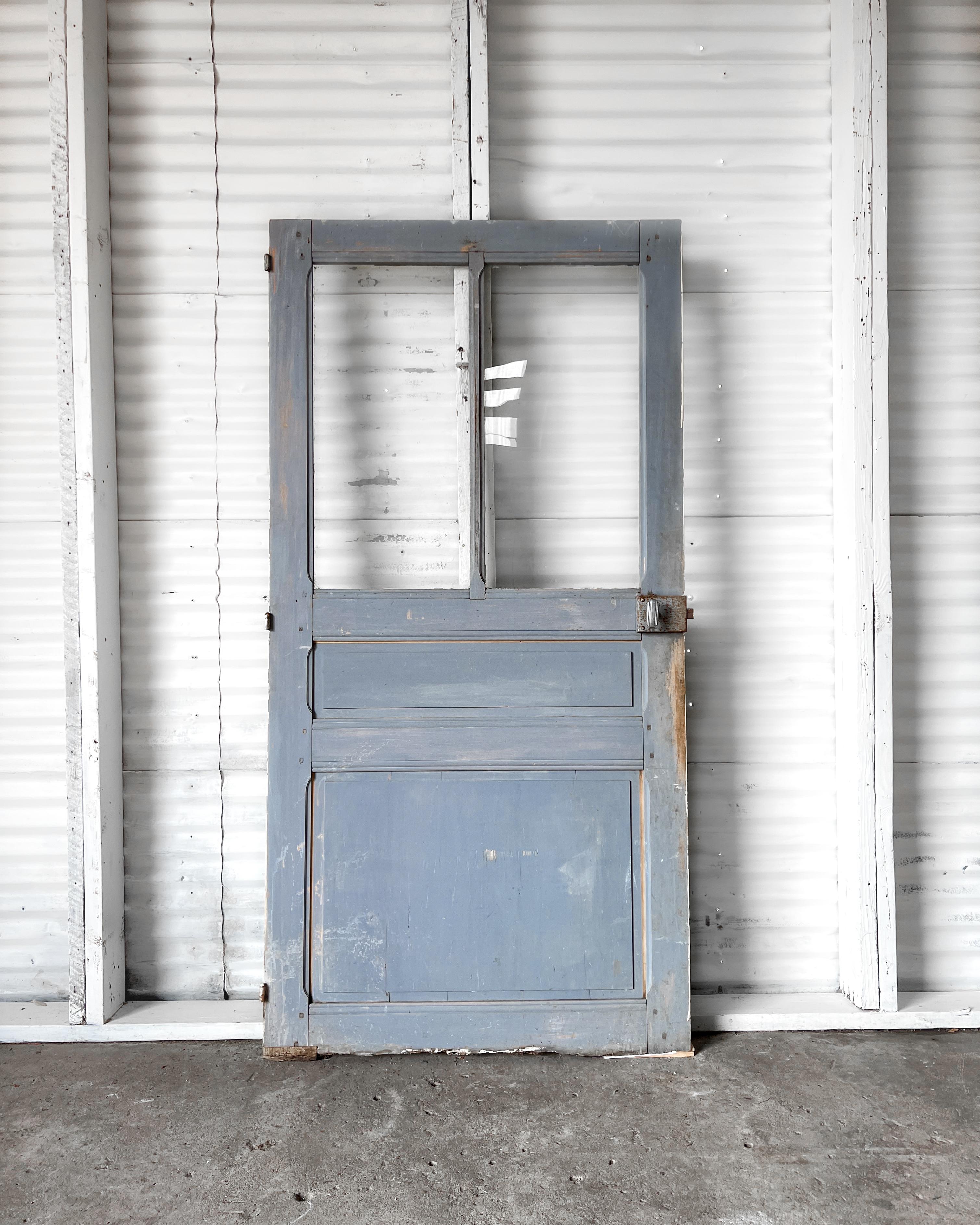 Reclaimed 19th-century French door featuring a 2-lite over 2-panel configuration. The exterior of the door features the original lovely periwinkle blue paint which will infuse your home with a layer of provincial charm and character.

Salvaged in