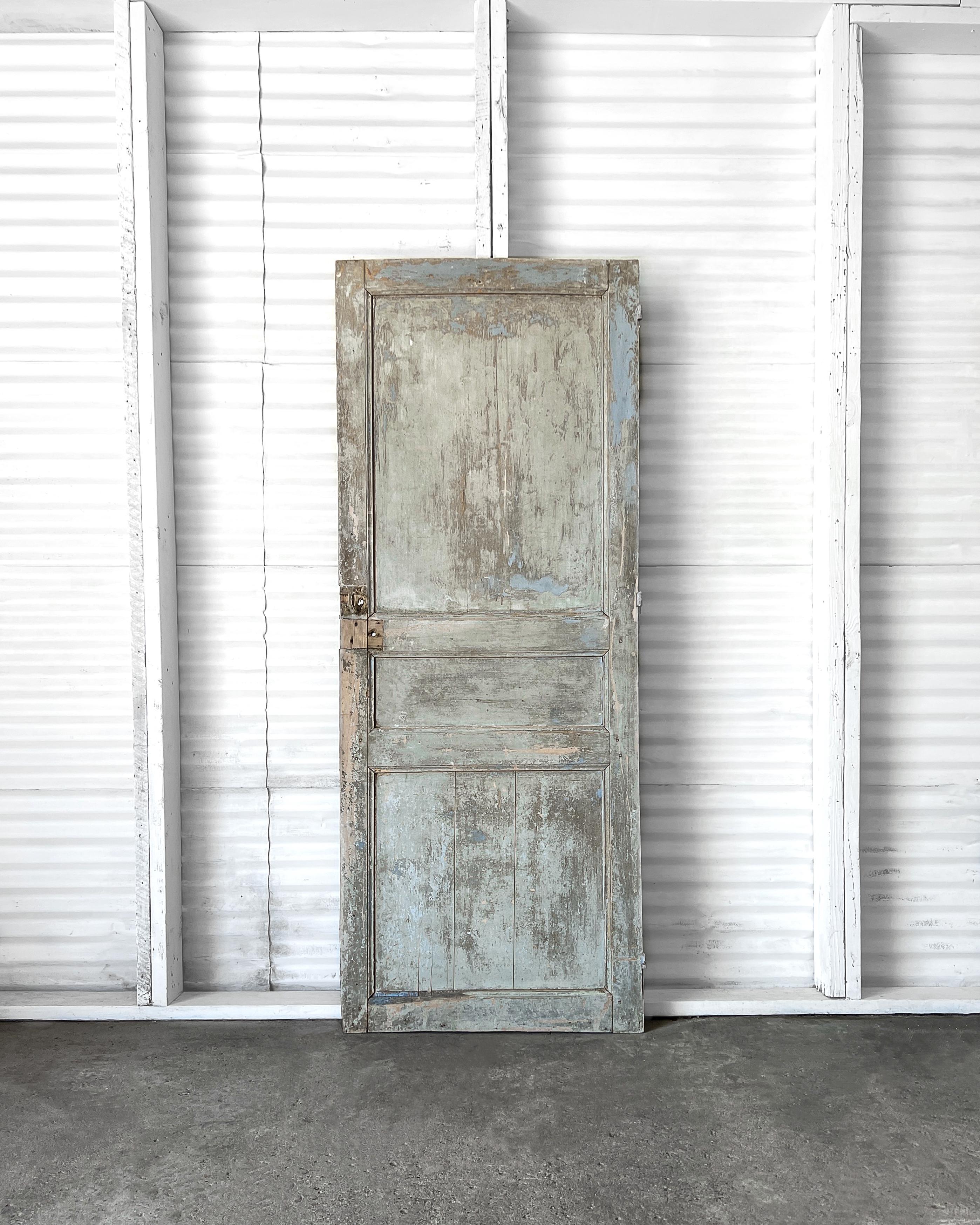 Eine aufgearbeitete, erhöhte 3-Paneel-Fenstertür mit gerillten und abgeschrägten Zierelementen. Mit ihrer wundervollen verwitterten Patina und den alten Farbschichten verleiht diese Tür einem neuen, modernen Haus sofort einen unvergleichlichen