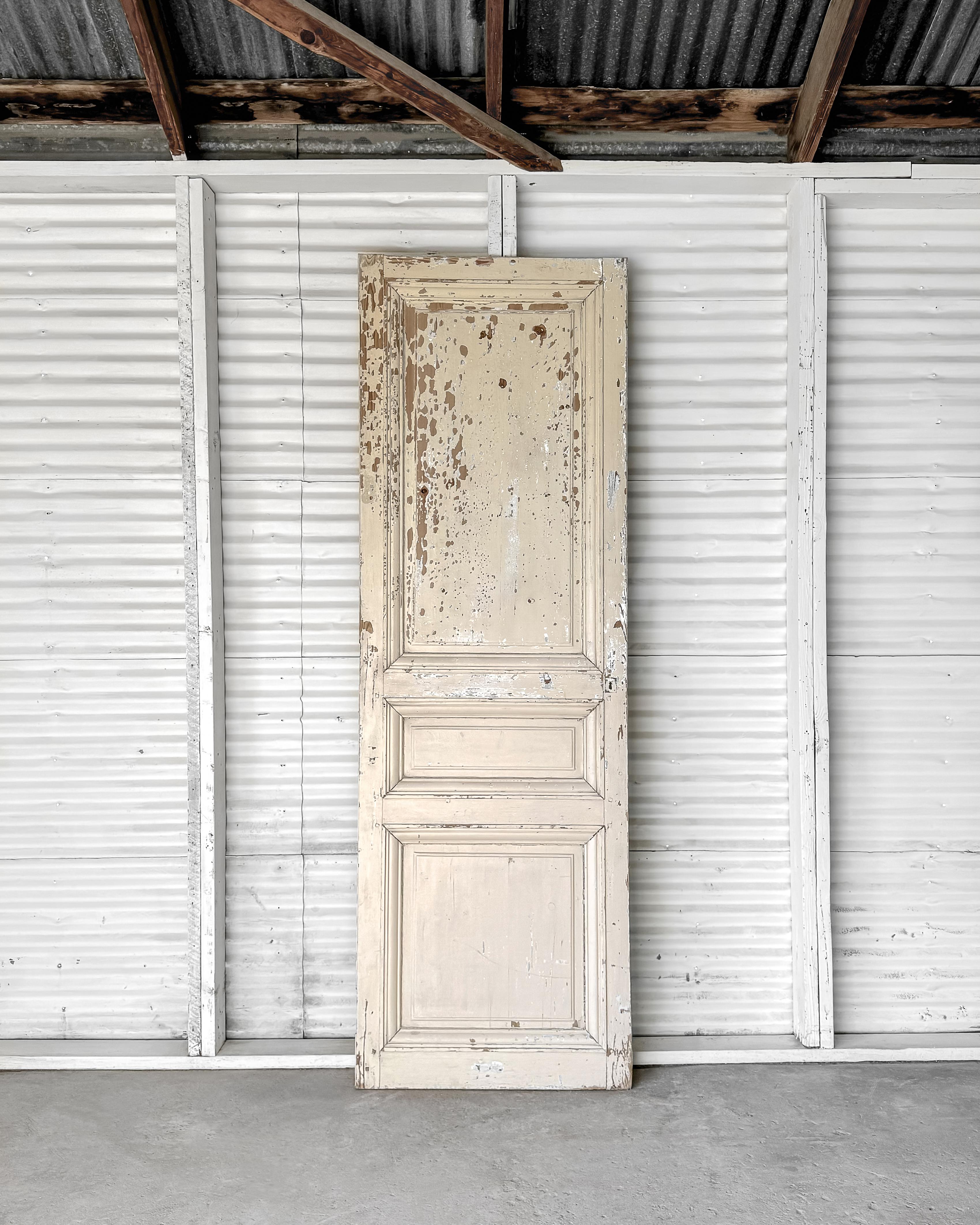 A reclaimed raised 3-panel configuration French door with grooved and beveled trim detailing and old weathered paint. Instantly add unrivaled character and charm when installing in a new modern home.

Salvaged in France, from the late 19th