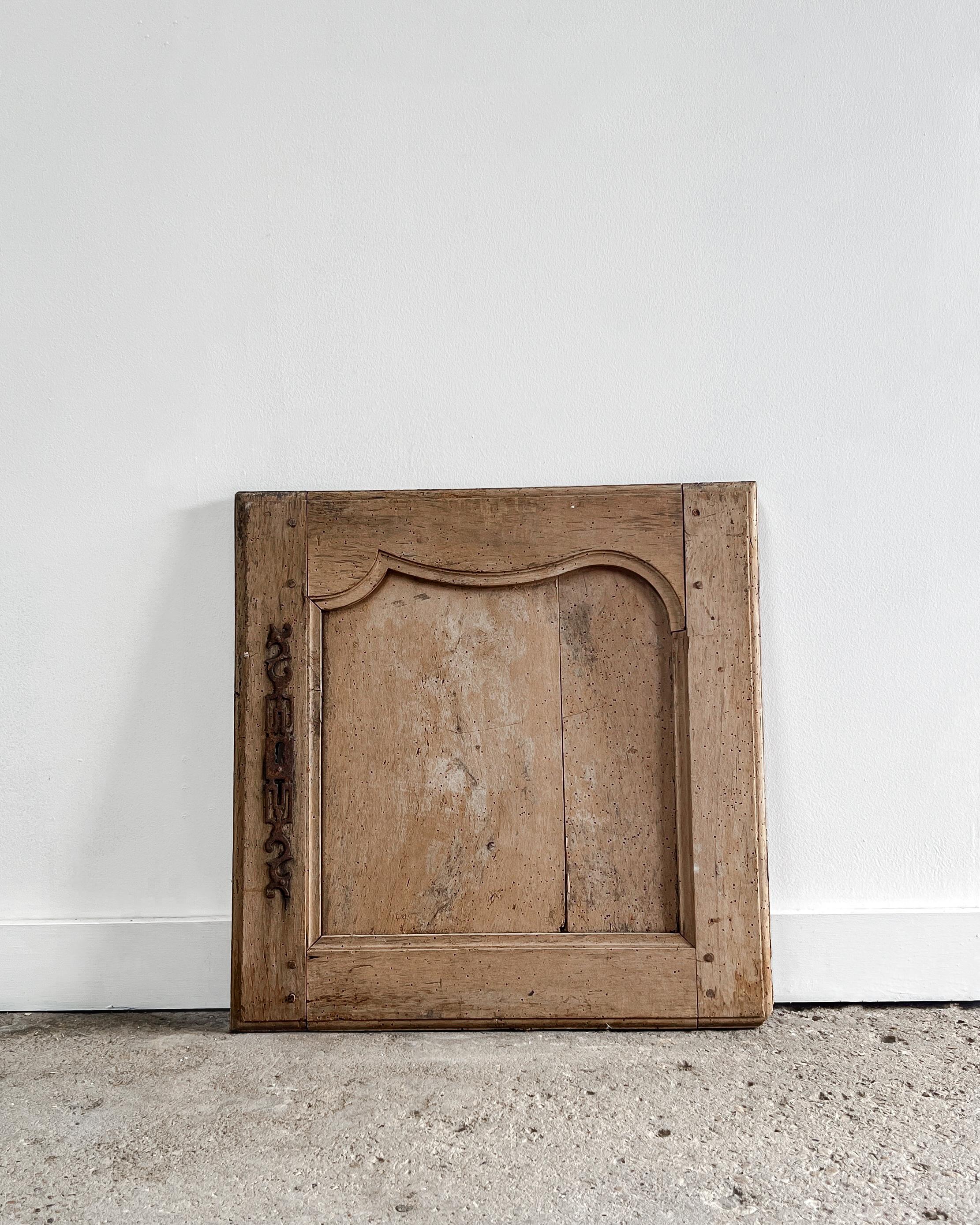 Un'anta di un bellissimo armadio di provincia impreziosita da intricati dettagli intagliati a mano. Recuperata da una casa del XIX secolo nella campagna francese, la porta è sapientemente realizzata in legno di frutta, con una bellissima finitura
