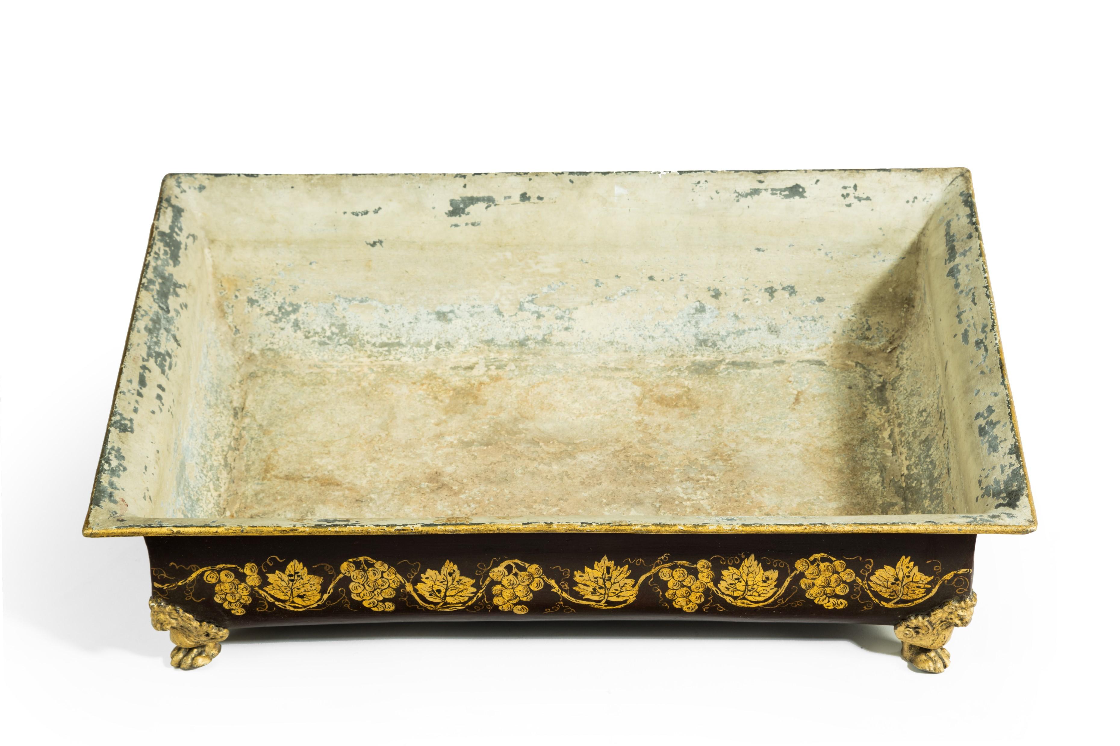 Delightful French rectangular shaped tole planter or wine cooler. Having fine gilt decoration of cascading grapes and vines on a rich aubergine ground. The whole is supported on lion masks on paw feet in each corner, French, circa 1860.