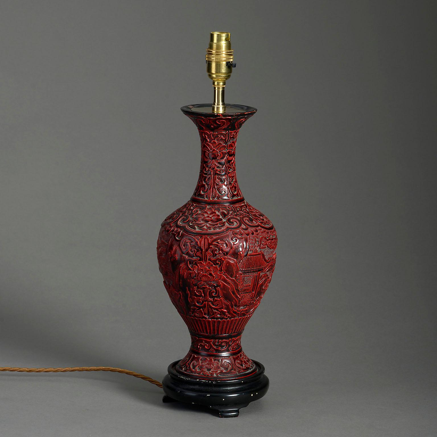 A late nineteenth century red cinnabar lacquer vase of baluster form and carved in the traditional manner. Now mounted as a table lamp and set upon an ebonised wooden base.

Dimensions refer to vase and base only.

 