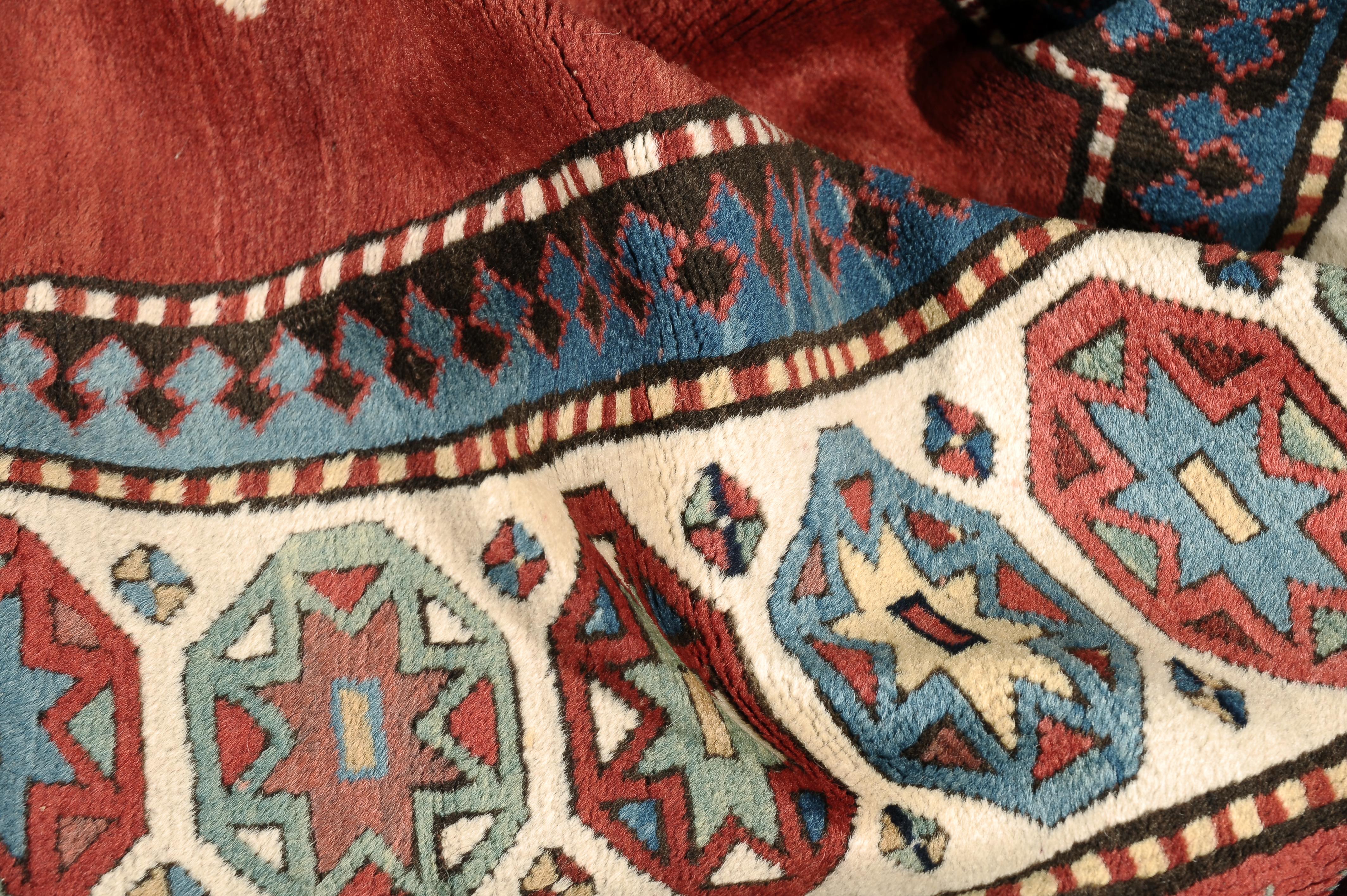 Antique Caucasian Talish runner from Karabagh region. Easily recognizable by the long and narrow (uncluttered) bold red field, ivory border with small octagon medallions and blue accents. This runner has an open Turkish weave in a medium pile.