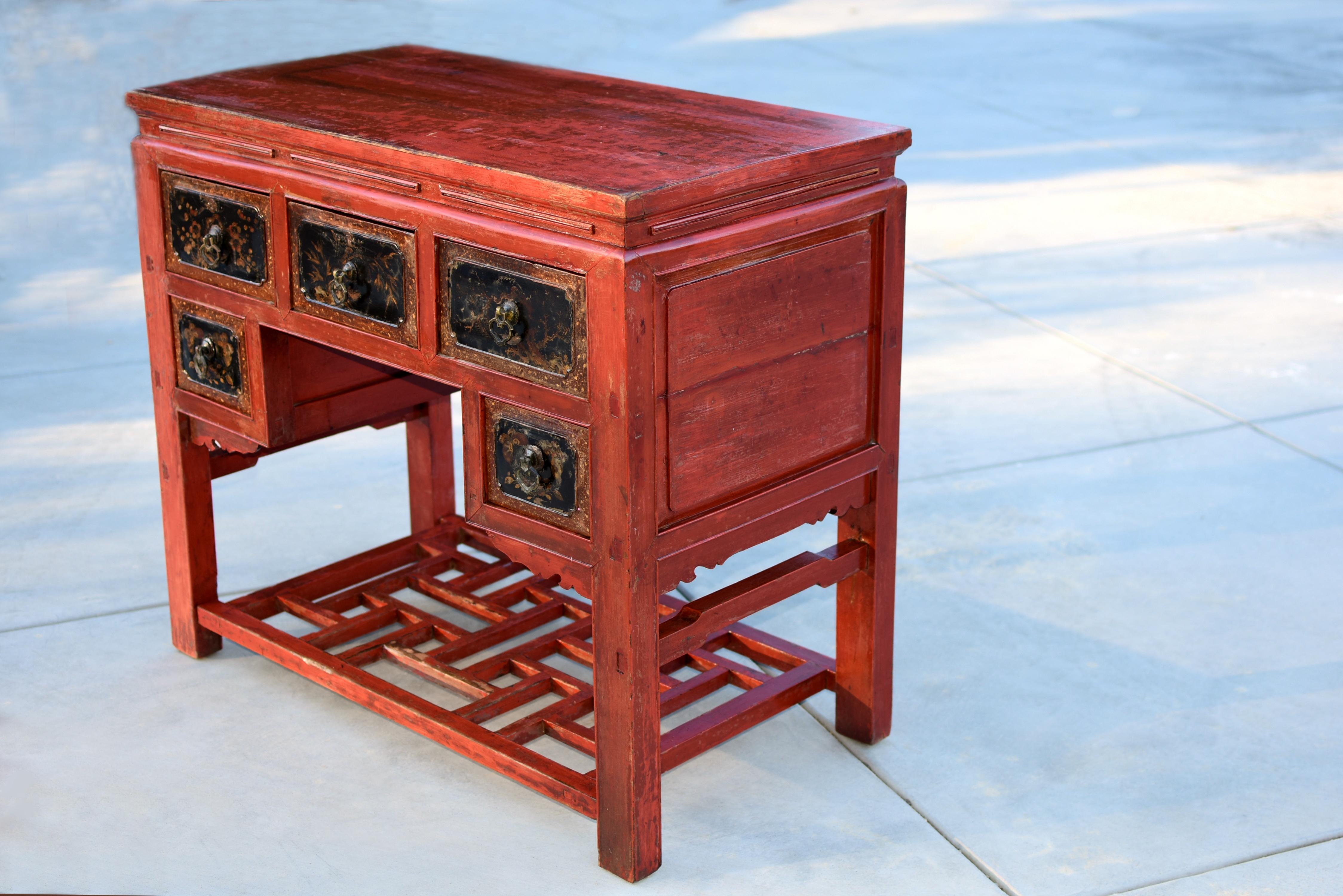 The 19th-century red lacquered solid wood Chinese table from Fujian province is a remarkable piece of late Qing dynasty craftsmanship. Solid single-board top is strong and stable, continuing down to a narrow waist with open light slits before