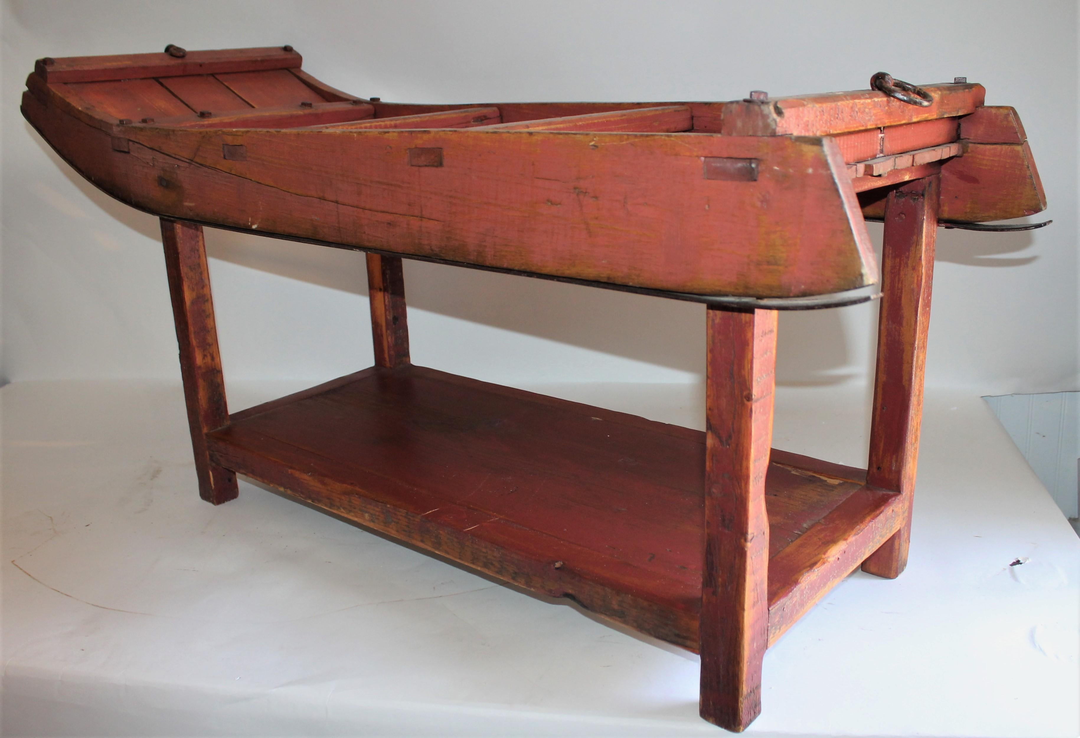 19th century original red painted New England snow sled turned into a coffee table. This sled is mortised construction and has the original iron sliders on the base.