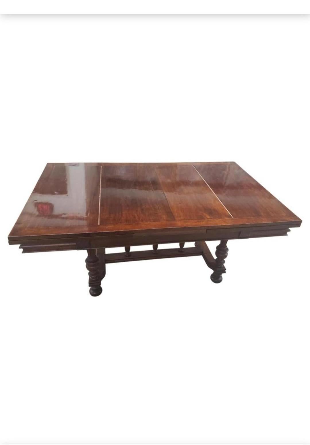 Antique Louis XVI solid walnut draw leaf dining table with top support provided by four substantial tapered and fluted column legs along with 3 columns over the stretcher design which allows maximum foot room yet sturdy reinforcement to the design.