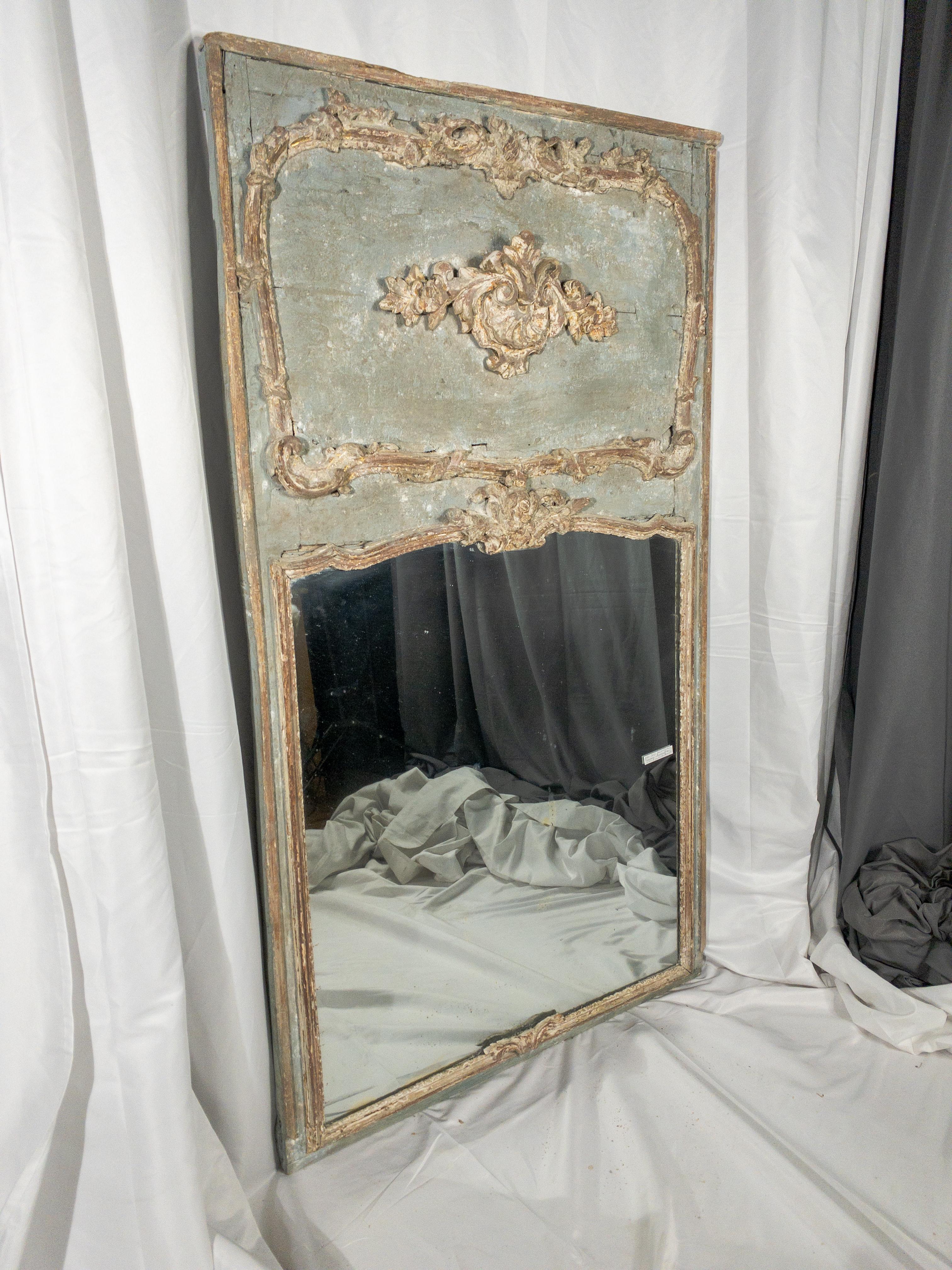 The 19th Century Regence Style Painted Trumeau Mirror epitomizes the sophistication and opulence of its era. Its intricate carvings, adorned with raised decorations delicately accented with traces of gilt, speak to the refined craftsmanship and