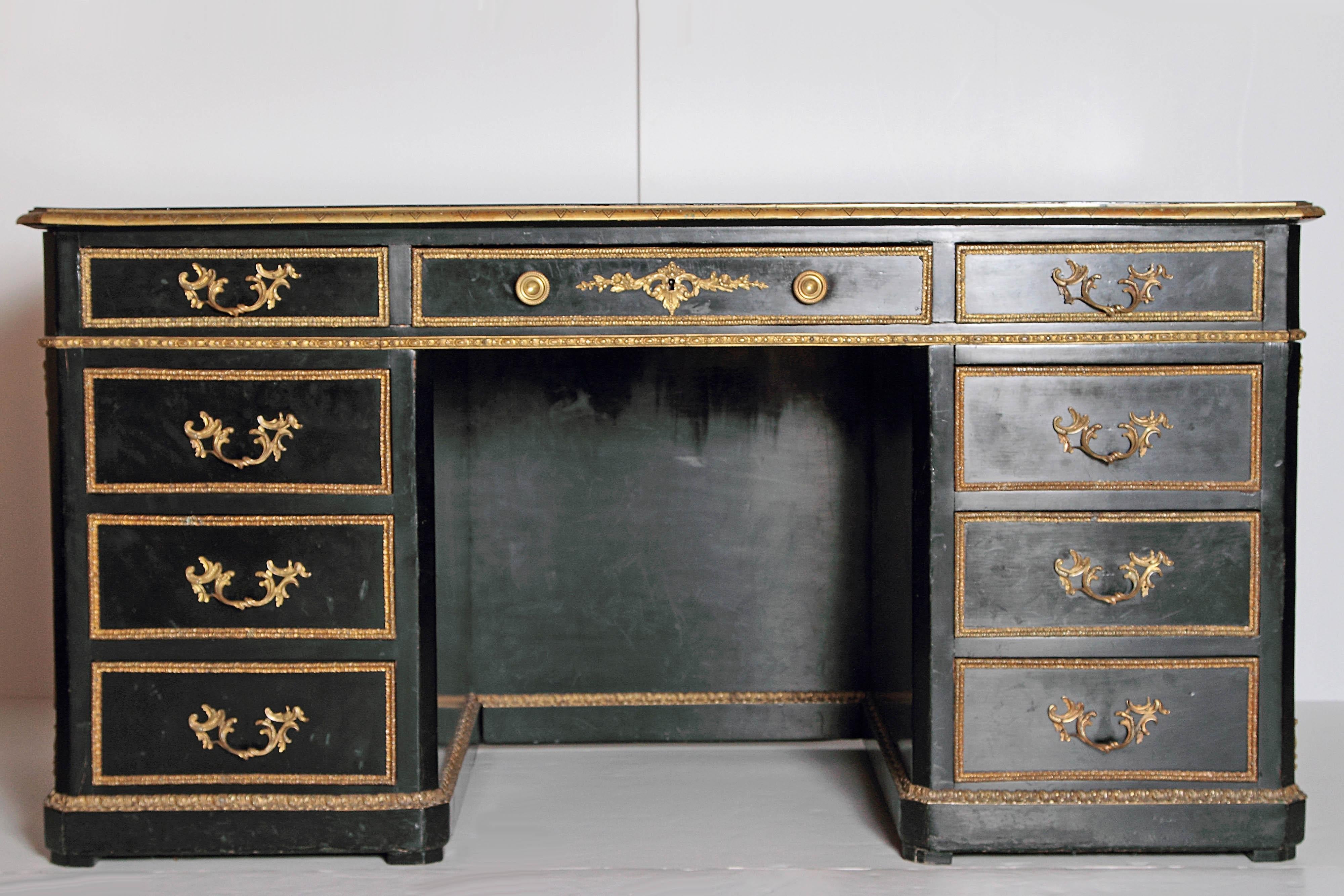 Ebonized 19th century French Regence style desk with gilt bronze mounts including satyr masks on each end and on the back. Black leather writing surface with embossing measures 52