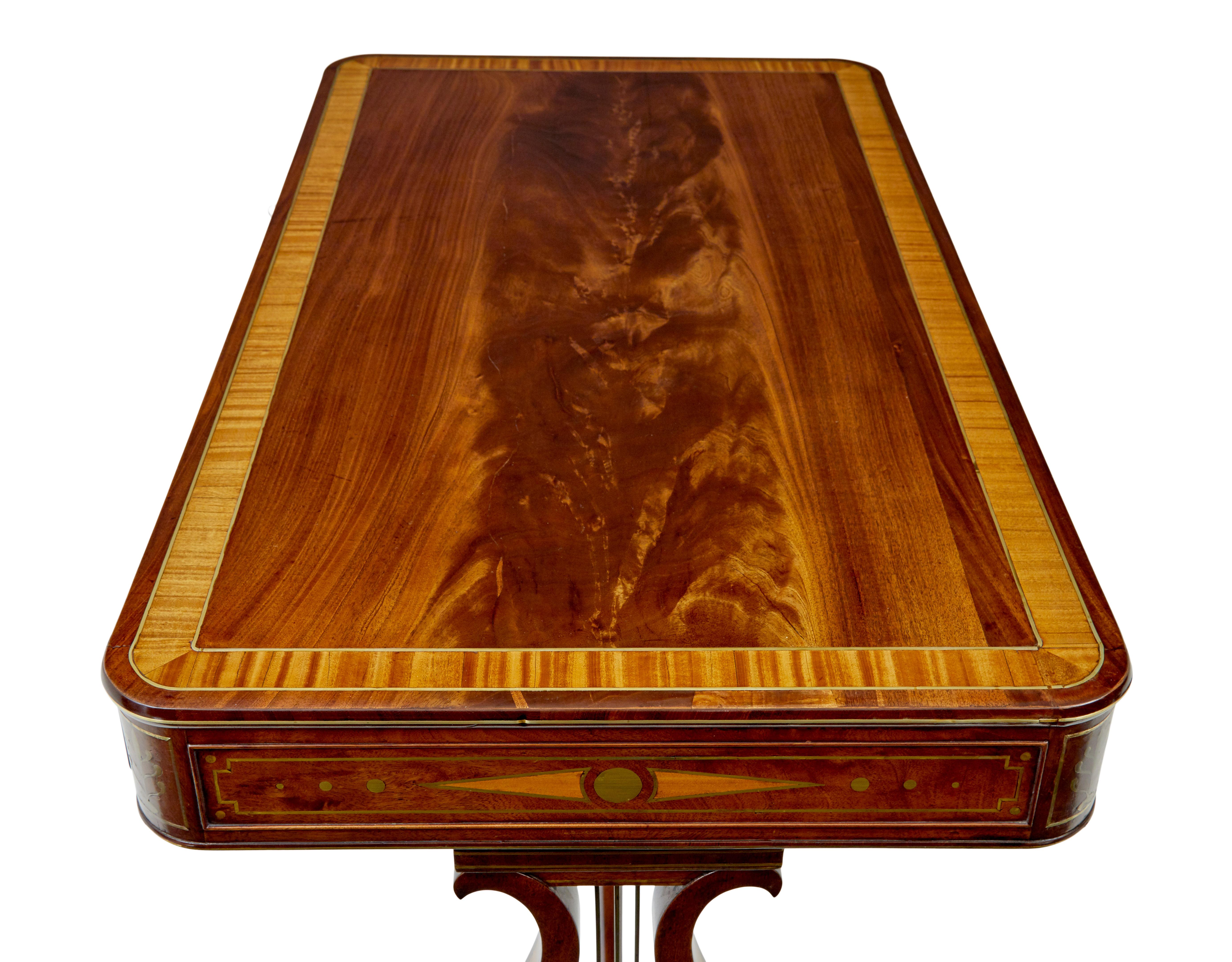 Scrivania reggenza in ottone intarsiato del XIX secolo, circa 1925.

Tavolino da scrittura di epoca reggenza di ottima fattura, riccamente intarsiato con corde e decorazioni in ottone.

Piano di scrittura rettangolare in mogano a fiamma con bordo a