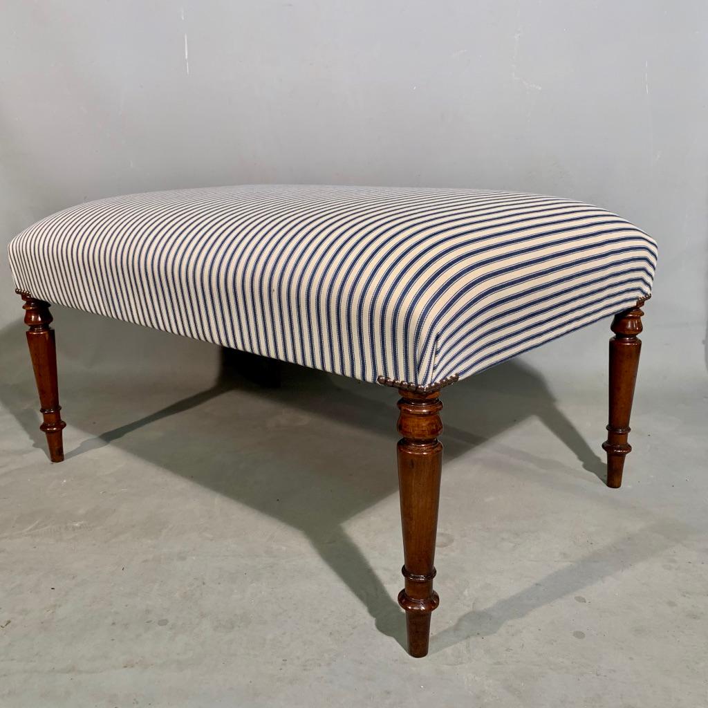Great decor piece, a Regency mahogany centre stool or footstool on beautiful turned legs, finished with a traditional ticking blue and white stripe and antiqued studs to the corners.
Useful piece for additional seating when needed too. Plenty