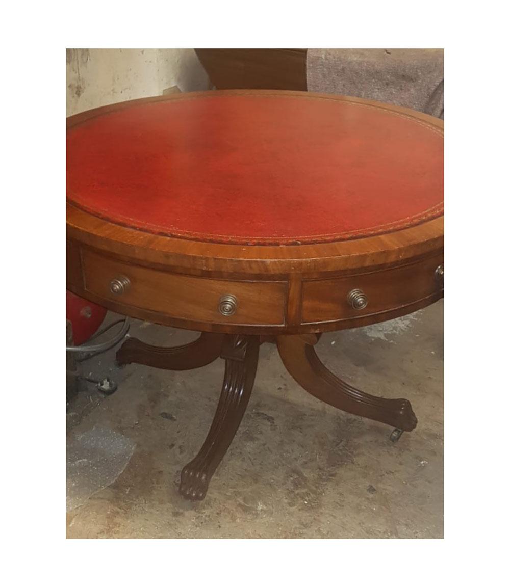 19th century mahogany drum table in the Regency manner, the gilt tooled red leather inset above eight frieze drawers with cock beaded edge, including four ring drawers raised on elegant ring turned baluster pod and four reeded out-swept legs with