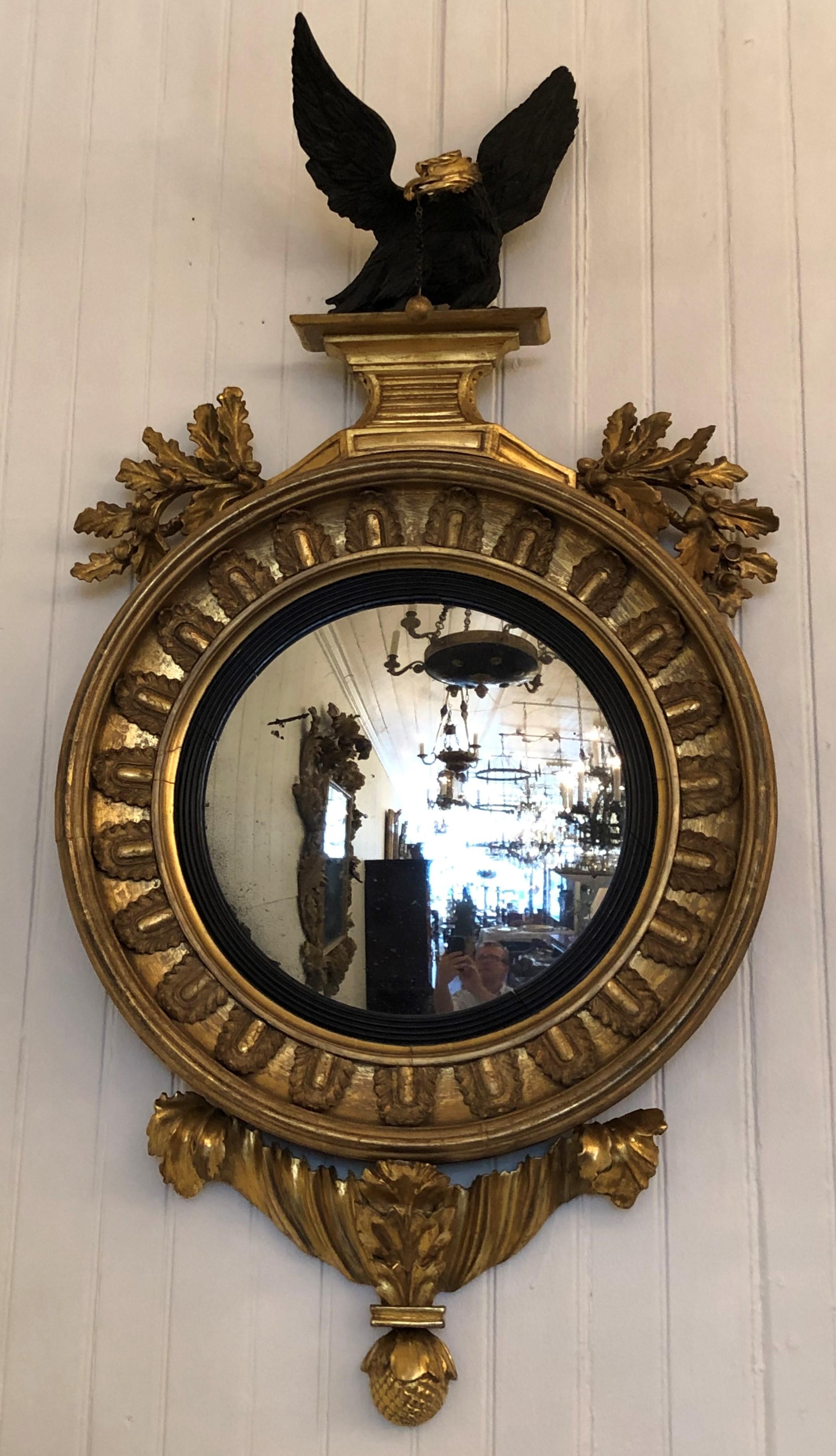 This convex mirror has a grand scale. The eagle has an ebonized body with a gilt head giving it a striking appearance which show off the feather details. The gilt head on the ebonized body ties in with the ebonized reeded ring making the mirror