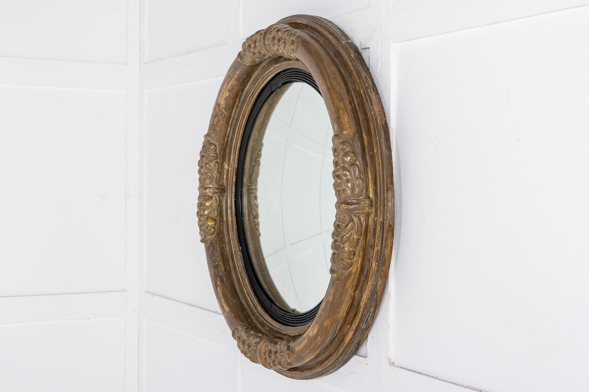 Der Spiegel hat eine typisch konvexe Form, aber einen Großteil der ursprünglichen Vergoldung und eine reizvolle, abgenutzte Oberfläche behalten. Die äußere Leiste ist in der Mitte jeder 