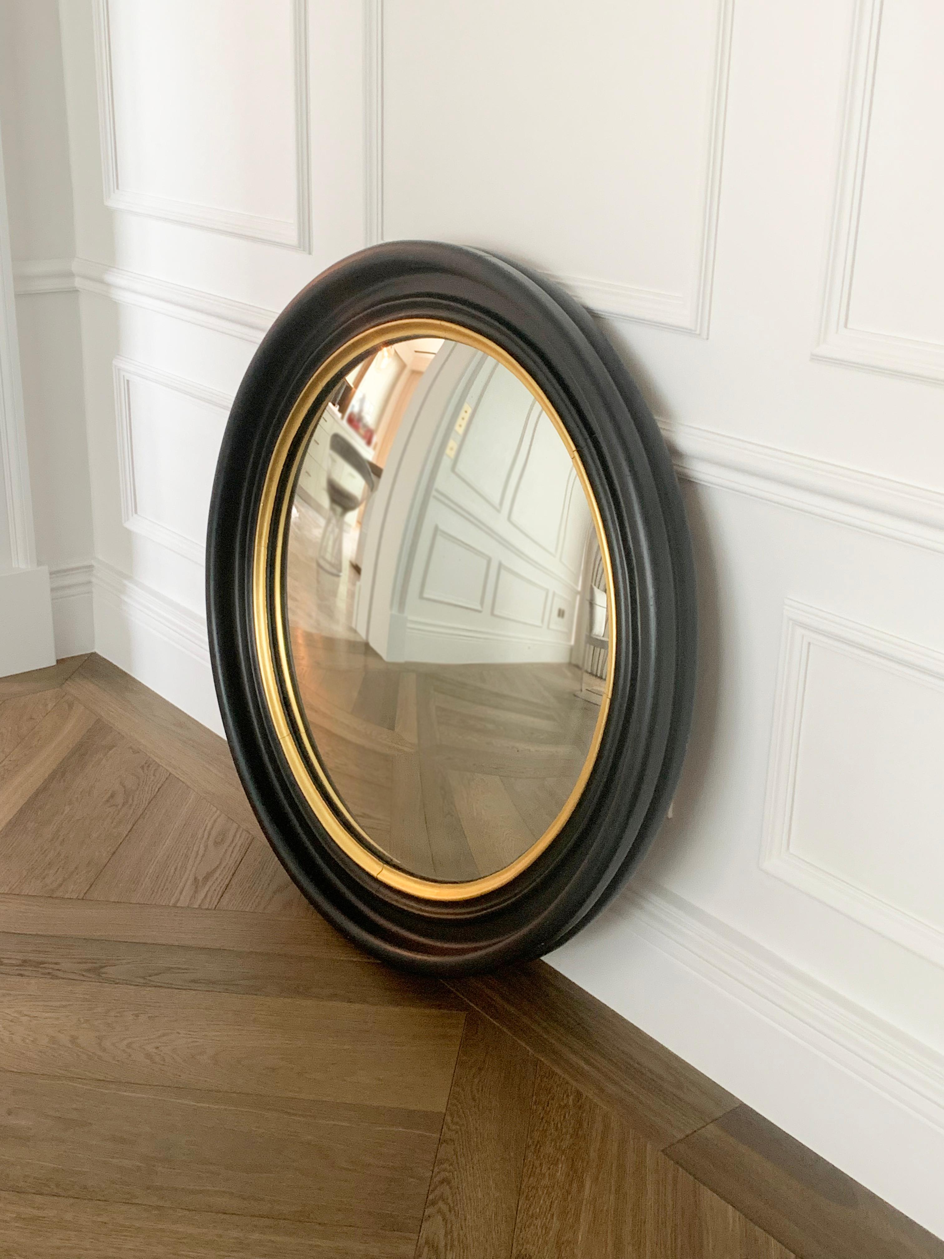 A pair of handmade Regency era wooden convex, bullseye mirrors 

Introducing a stunning pair of Regency-era convex ship mirrors, expertly hand-carved and crafted with a thick black and gilt wood frame. 

The convex/bullseye mirrors exude timeless