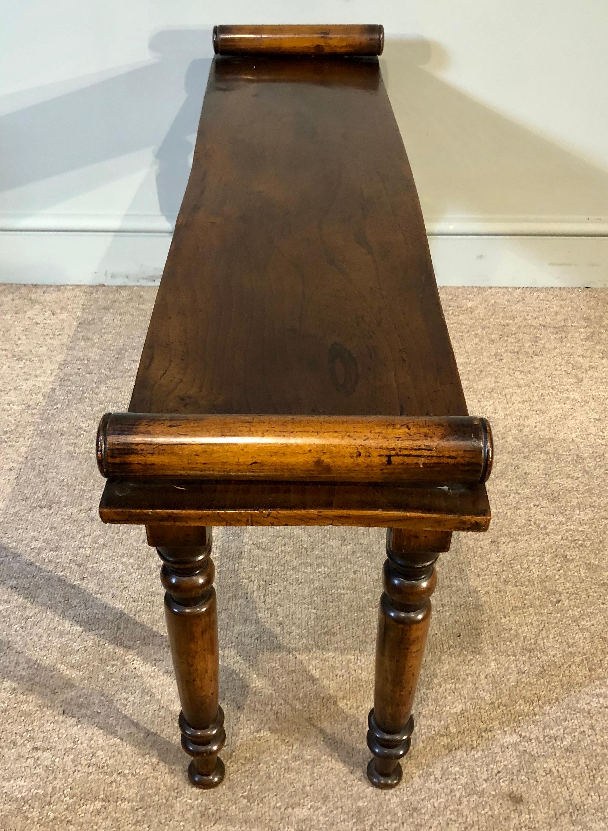 An attractive and well-proportioned Regency style 19th century mahogany and elm window seat. The beautifully figured elm seat top having scrolls at each end, standing on four turned mahogany legs. Works perfectly at the end of a bed, or as a window