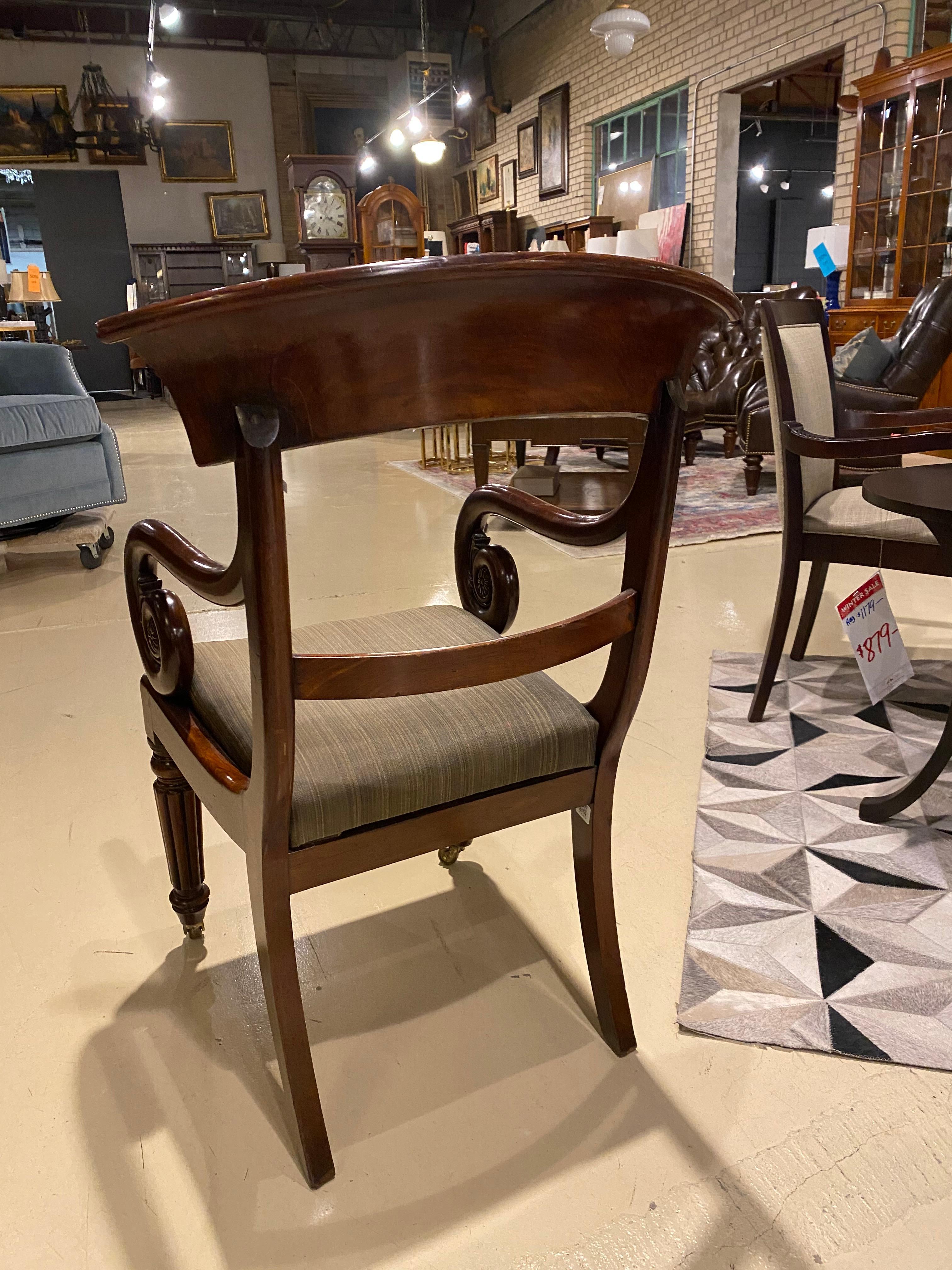 A fine arm chair from the English Regency period in mahogany with a scroll arm. This would be a fantastic arm chair to add a bit of character to a library or to be used as a compliment to an antique desk. The mahogany has developed a lovely patina