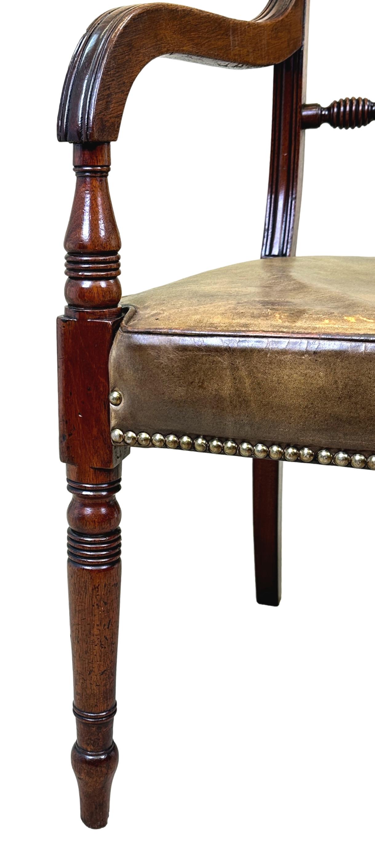A Very Good Quality Early 19th Century, Regency Period, Mahogany Desk Armchair Having Superbly Figured Top Rail And Carved Rope Twist Decoration To Back, With Scrolling Arms And Leather Upholstered Seat, Raised On Elegant Turned Tapering