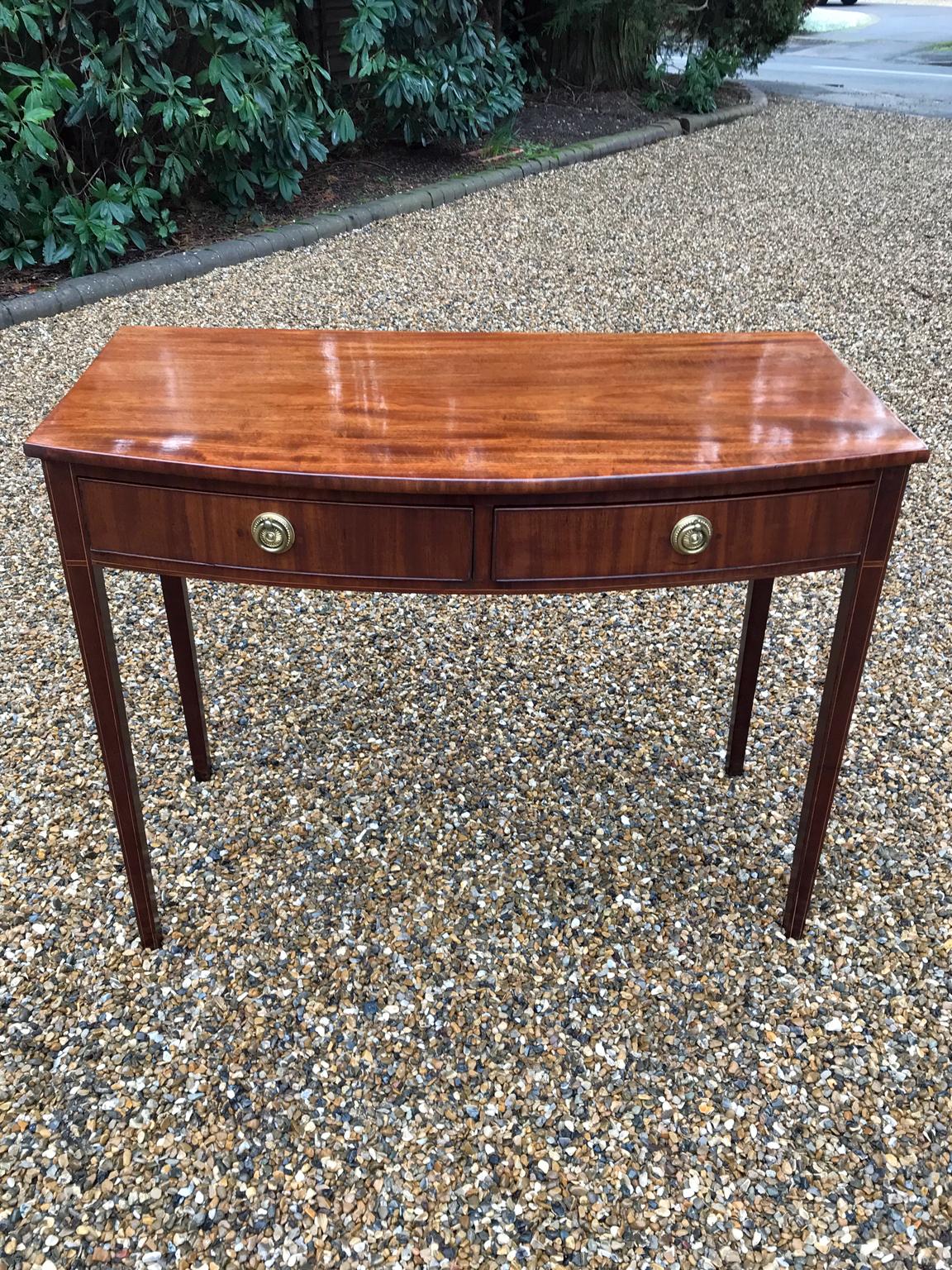 19th century English Regency mahogany bow fronted side table, fitted with two mahogany drawers and brass ring handles, on square tapering legs,

circa 1830.

Dimensions:
Width 38.5 inches – 98 cms
Side depth 17 inches – 43.5 cms
Height 30.5