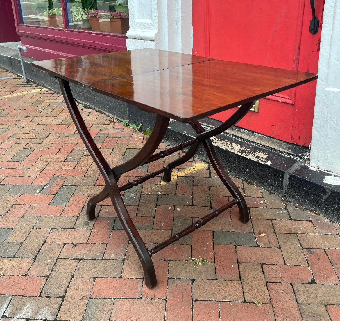 19th century English mahogany coaching table. Made during the height of the patent and campaign furniture rage this piece was designed to be folded and taken with you for a little sophistication while on the hunt or campaign. The table folds in half