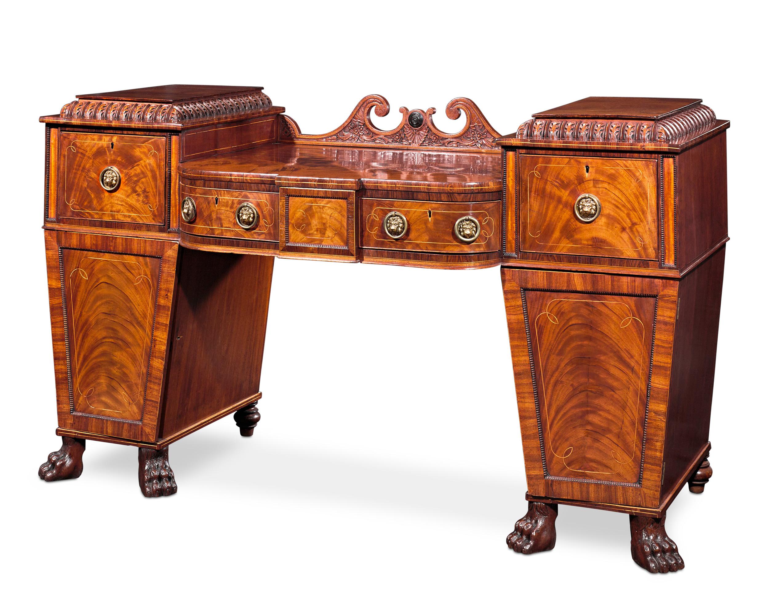 This monumental English mahogany sideboard captures the luxury of the Regency era in grand style. Crafted in the neoclassical taste, the sideboard evokes the stately forms of ancient Greek and Roman architecture in its beautifully proportioned form