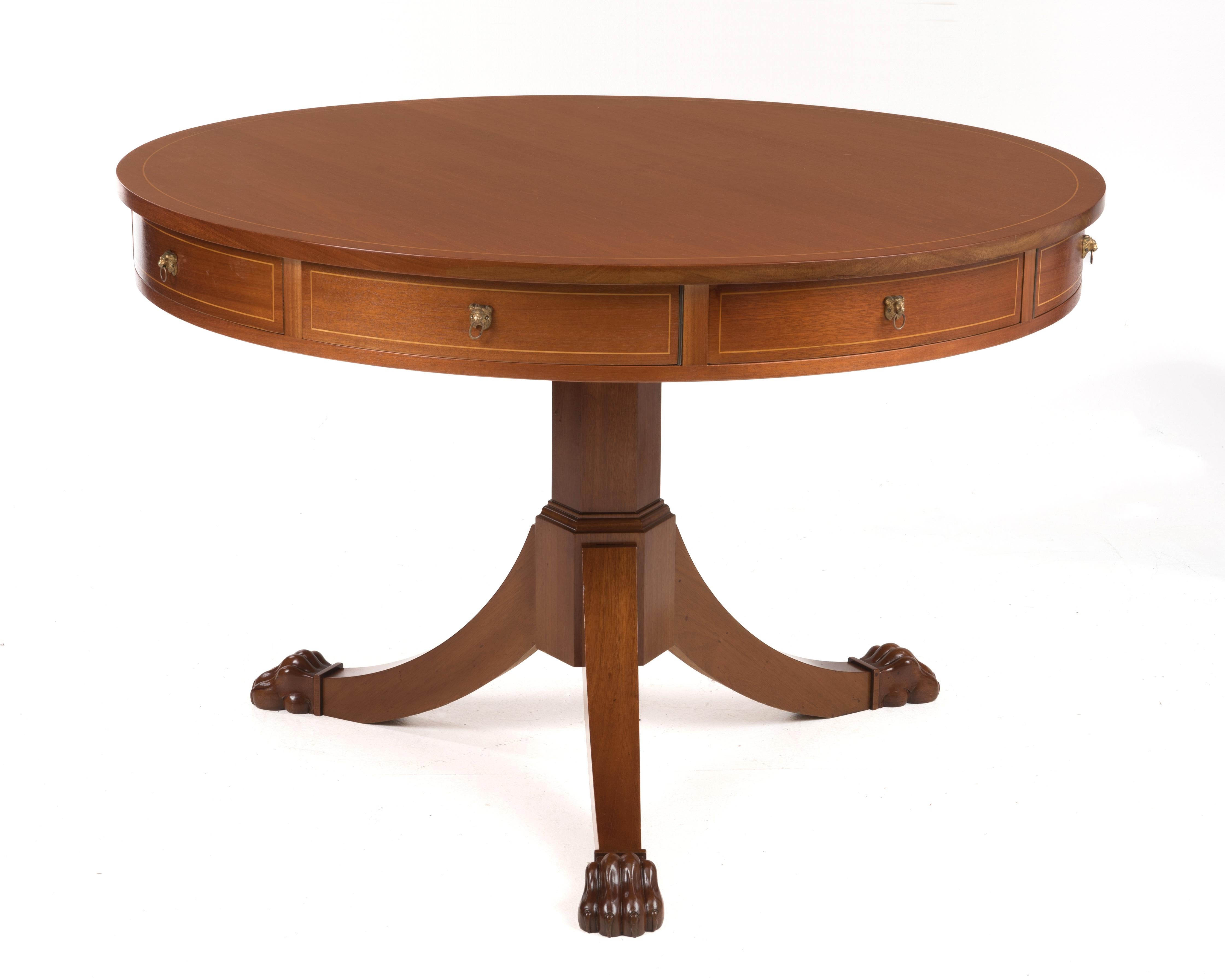 A large and impressive antique Regency style rotating rent table. Mahogany throughout, inlaid top with carved paw feet and brass lion head hardware. Purchased direct from an estate and we were told the table was purchased by a family member in
