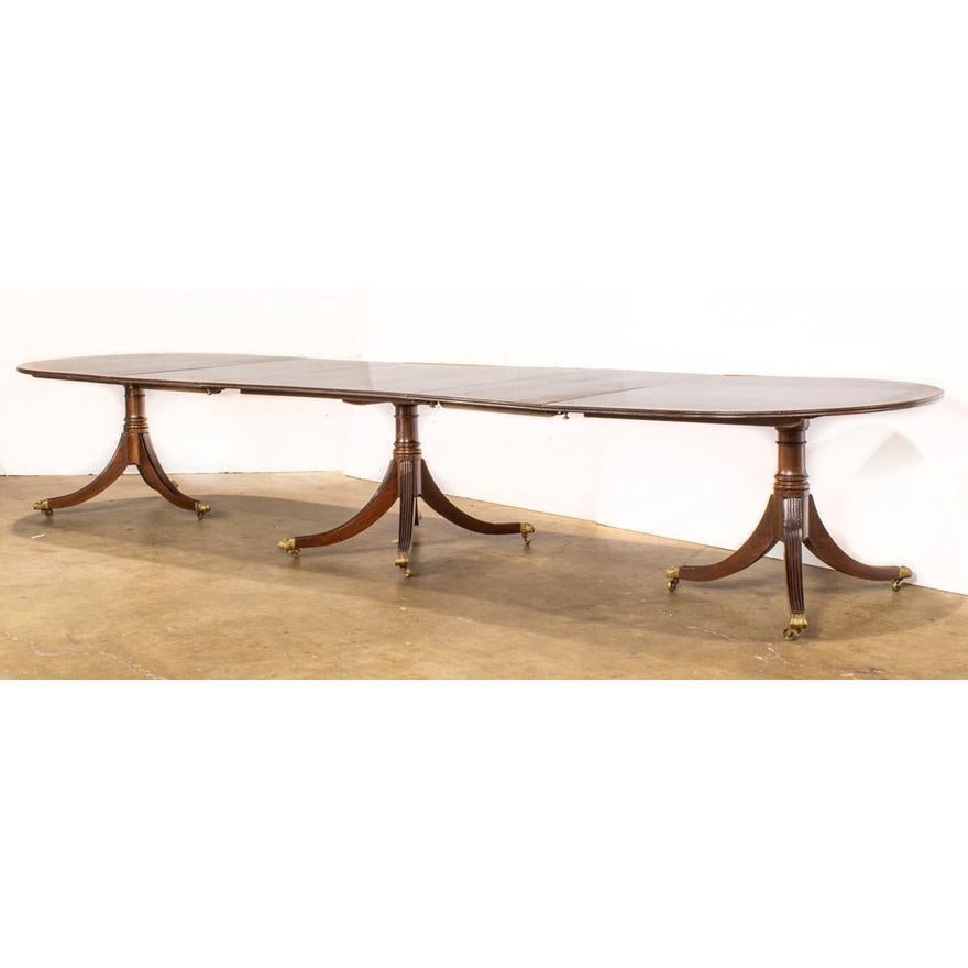 Table de banquet Regency à triple piédestal en acajou, vers 1820, la table ovale est en acier inoxydable.
Le plateau est orné d'une incrustation de bande, avec deux feuilles de 23
