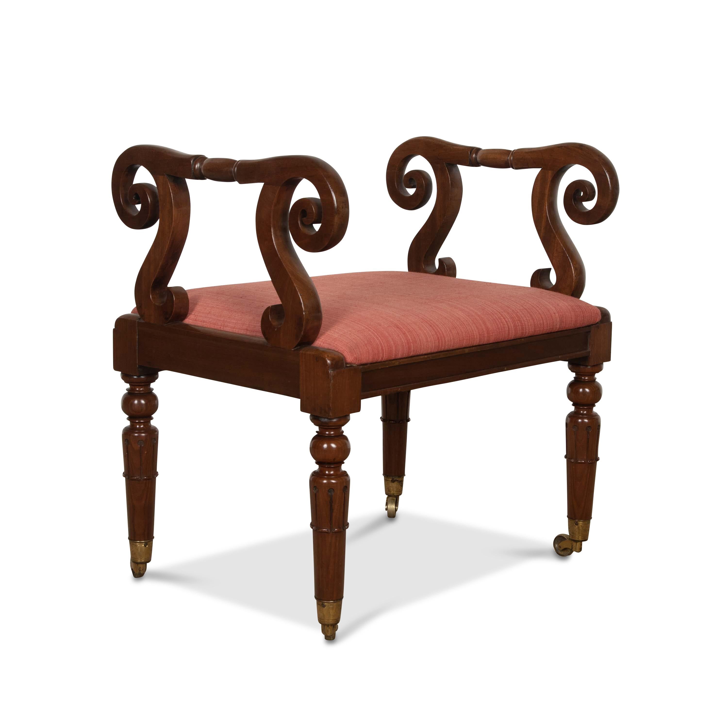 A smart Regency mahogany Stool/Window seat, the raised armrests with elaborate scrolls and S shape supports, the seat with moulded frame and raised on tulip carved tapering legs with gilded brass cup castors. Good size and excellent condition. Circa
