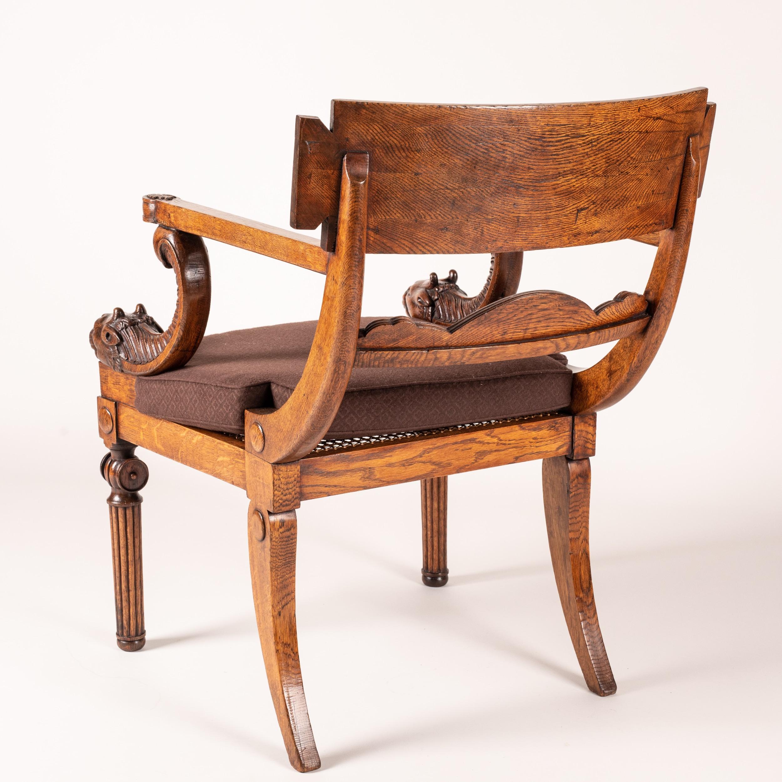 A Regency Period Klismos armchair
In the manner of Thomas Hope

Carved from oak, with the typical Klismos construction having sabre back legs, the tapering front legs turned and reeded with baluster capitals; the swooping and curved studded